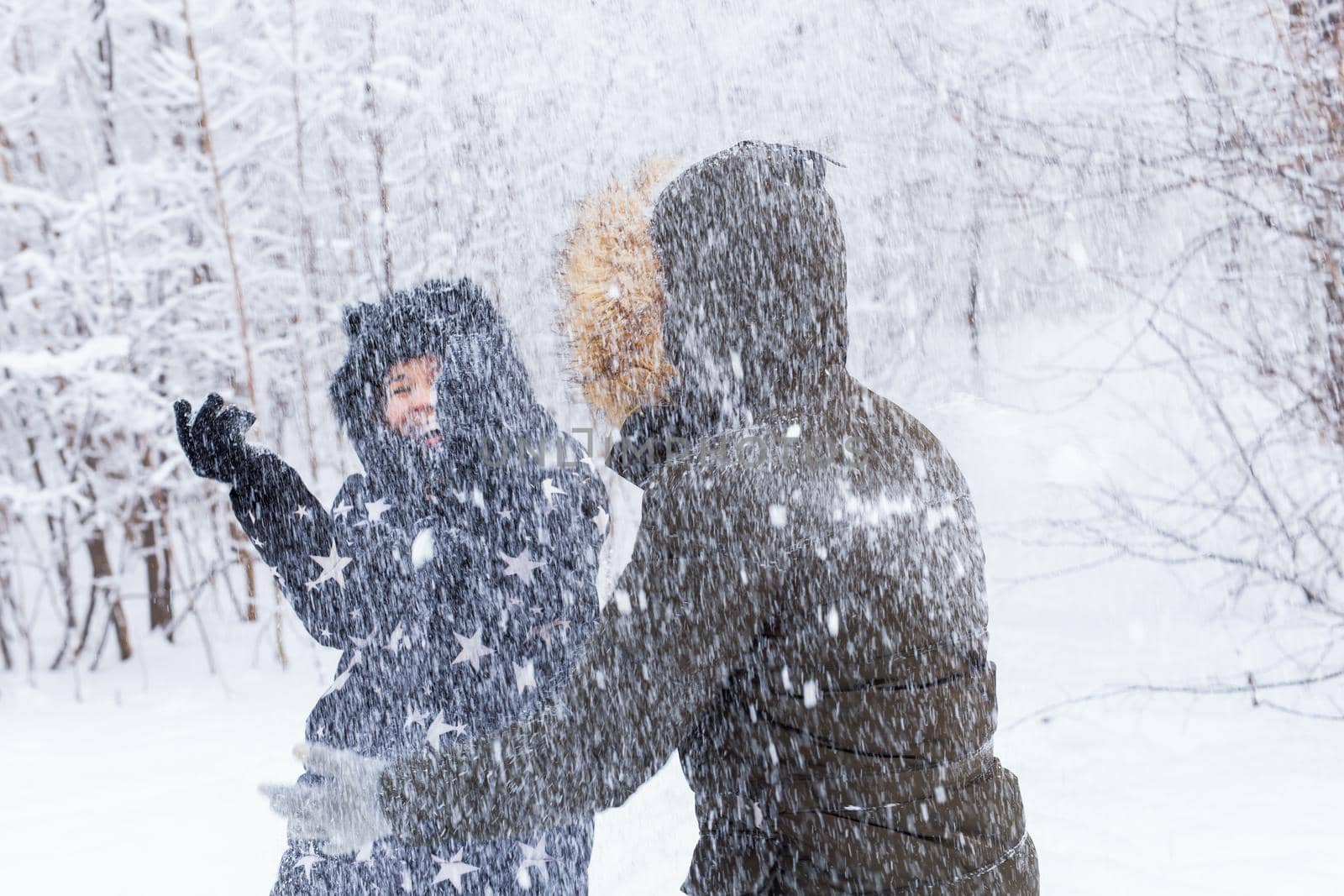 Fun, season and leisure concept - love couple plays winter wood on snow