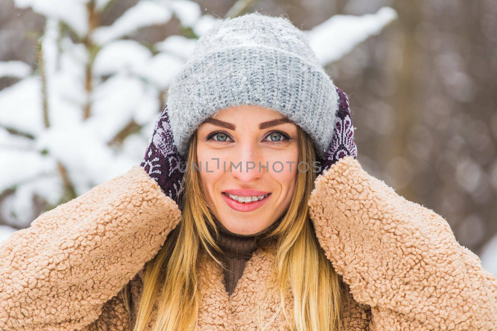 Portrait of a beautiful woman with braces on teeth. Smiling girl with dental braces. Happy smiling woman with braces in winter nature. Dental Health Concept. by Satura86