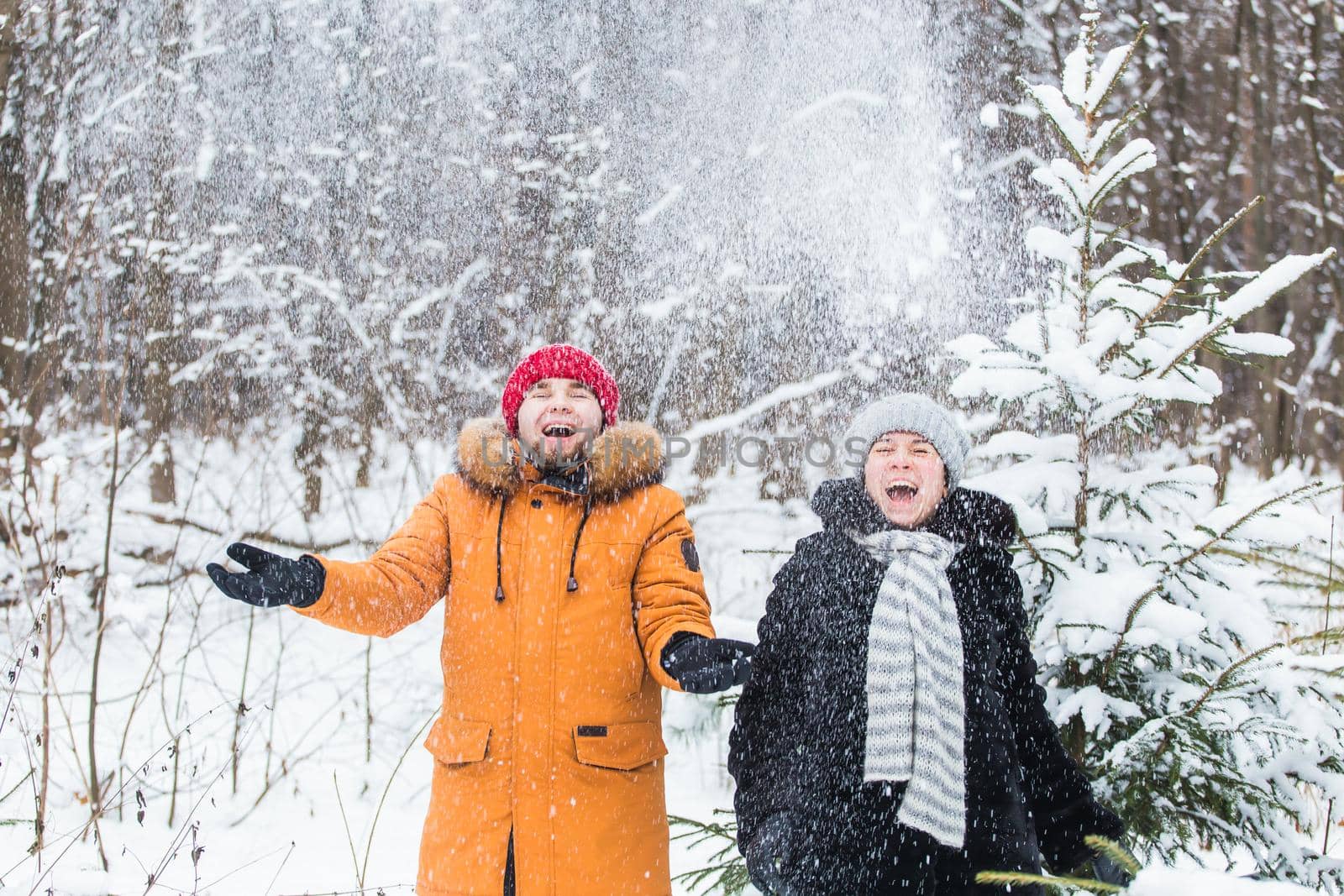 Love, season, friendship and people concept - happy young man and woman having fun and playing with snow in winter forest by Satura86