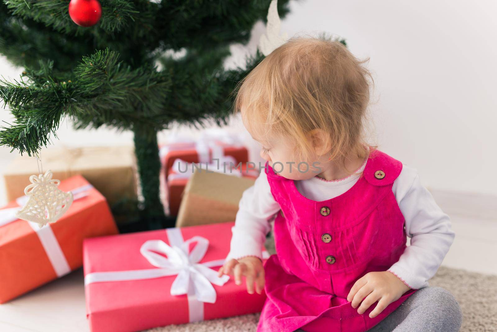 Child holding Christmas gift. Kid having fun at home. Xmas winter holiday.