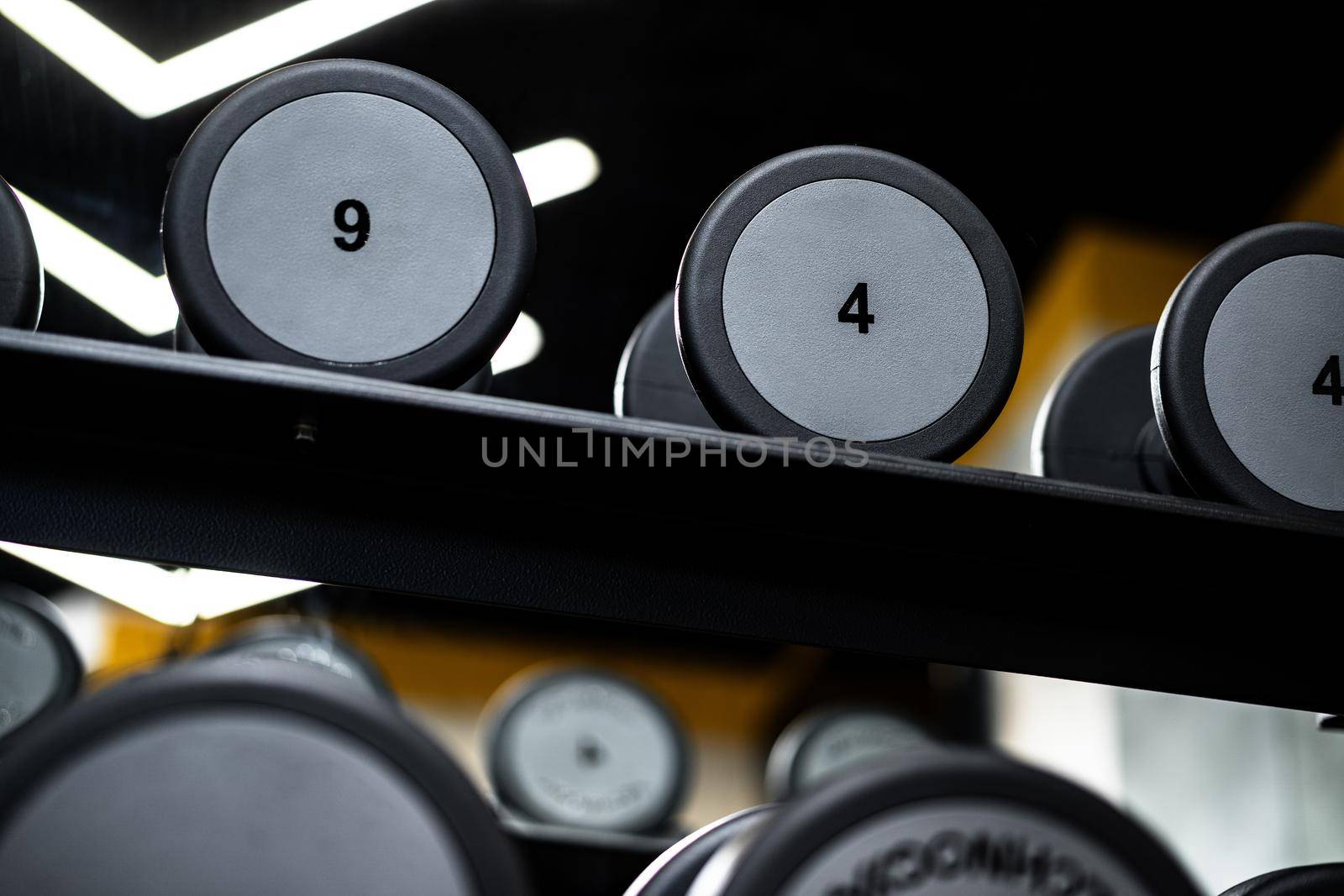 Close up photo of new dumbbells on a rack in a gym
