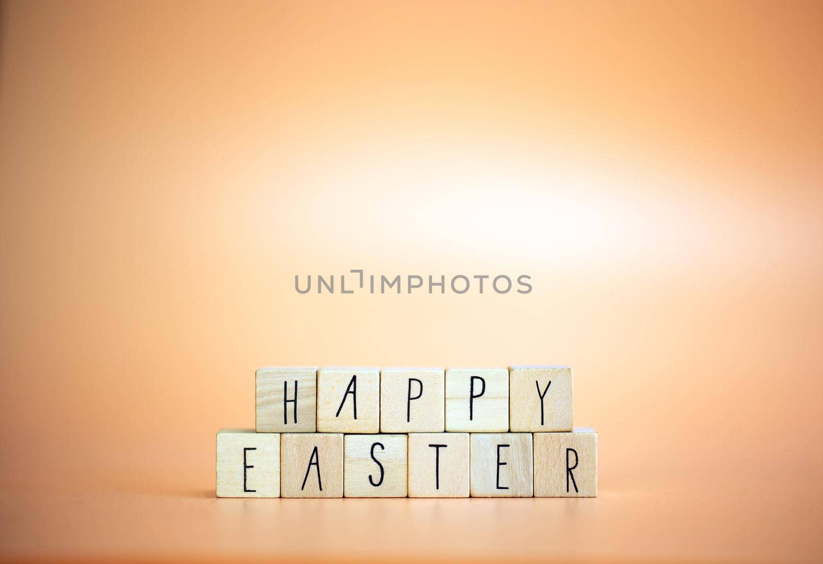 Happy Easter written with pastel colored orange background and bright spring flowers, greeting card,spring,colors,Easter Holiday concept copy space space for text