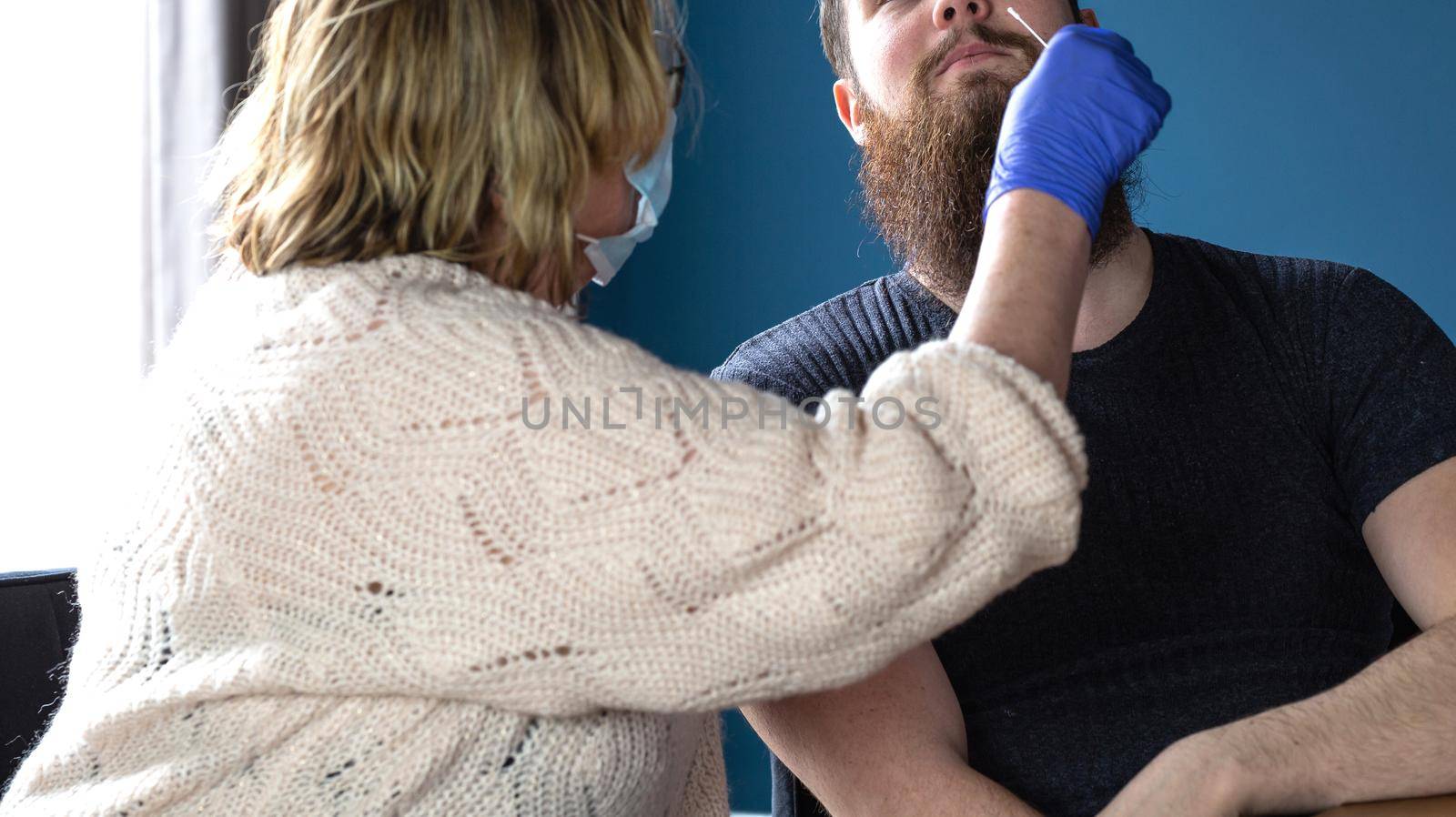 Woman doing nasal swab with self test kit at home from a young man for testing possible coronavirus infection. Covid-19,Coronavirus,Healht,selftest concept close up