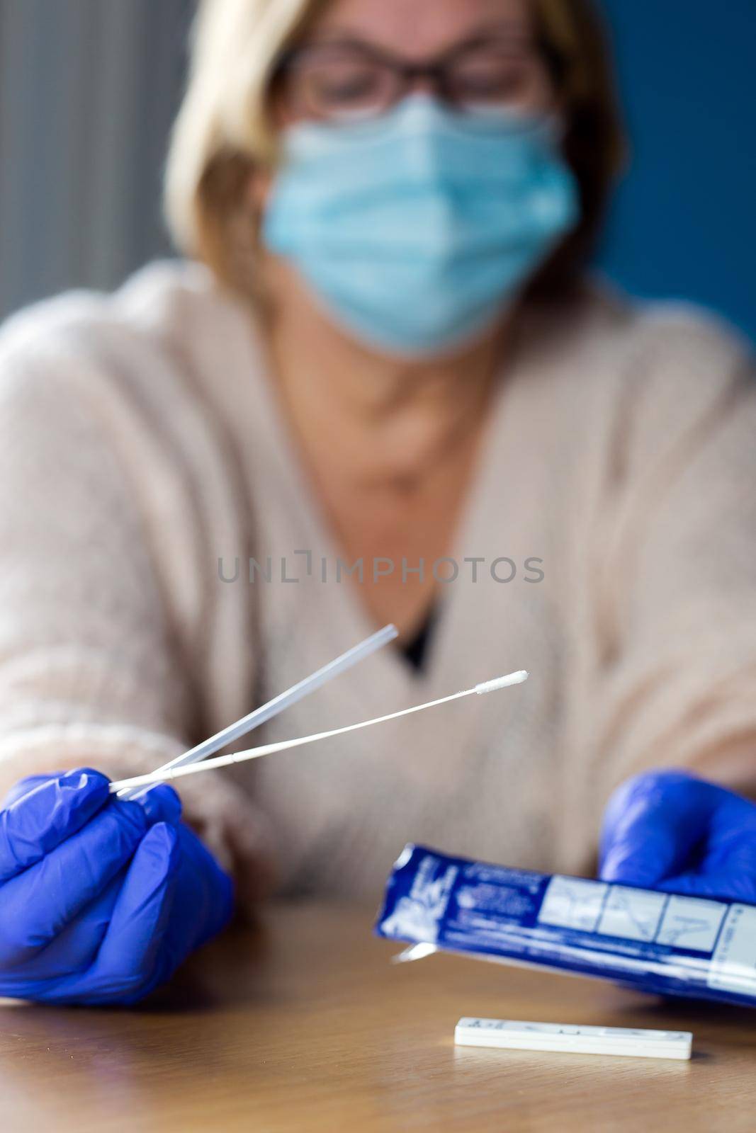 Senior woman studying and taking the self test for Covid-19, home test kit for coronavirus close-up