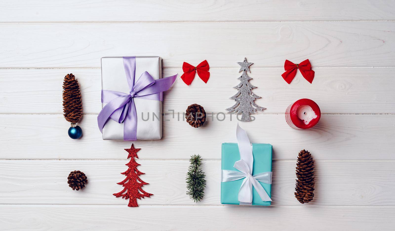 Christmas gifts and decorations on white wooden board, top view