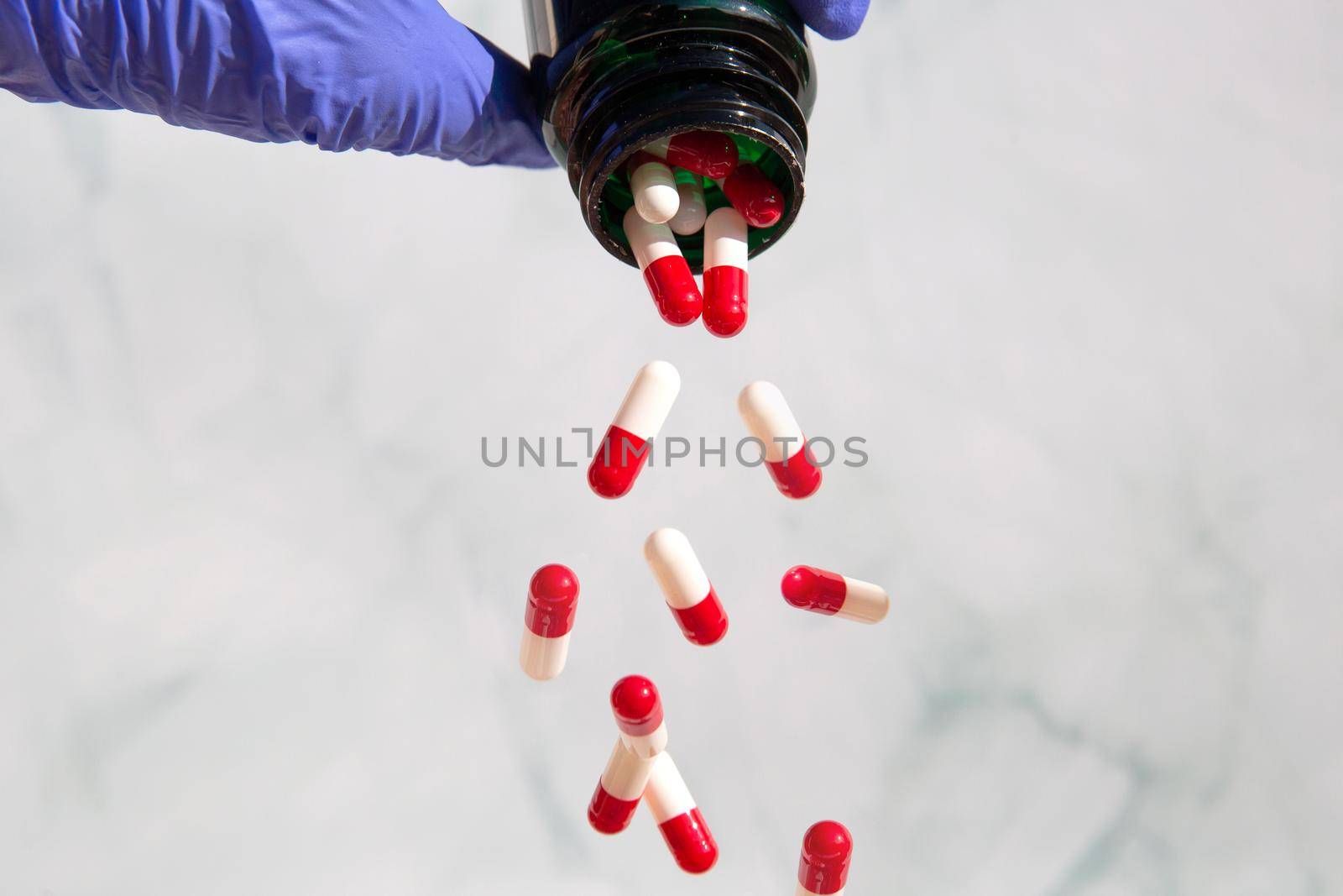 A hand grabbing pharmacy jars full of medicines, Capsules falling out Vitamines,drugs,medication. Health,business concept copy space background