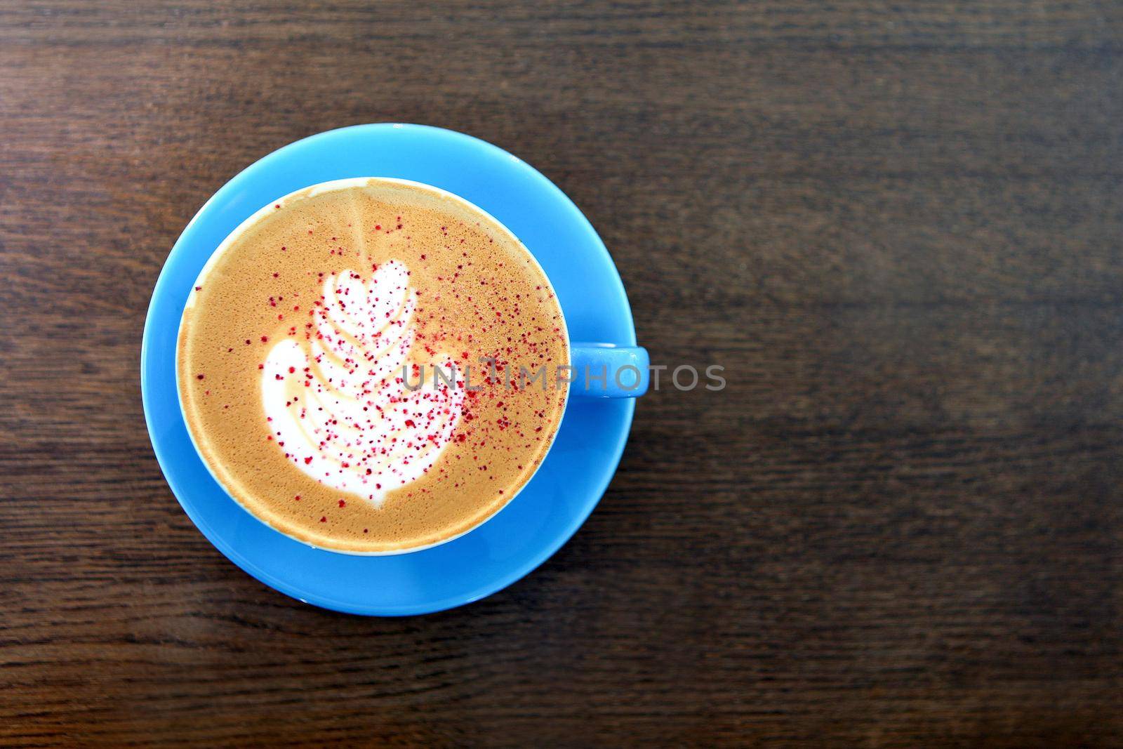 Big Coffee cup with milk on the wooden table. cappuccino or latte drink, cup of coffee on brown table flat lay view. Cup of cafe au lait. Milk paintings or latte art. Hot Coffee in a blue mug