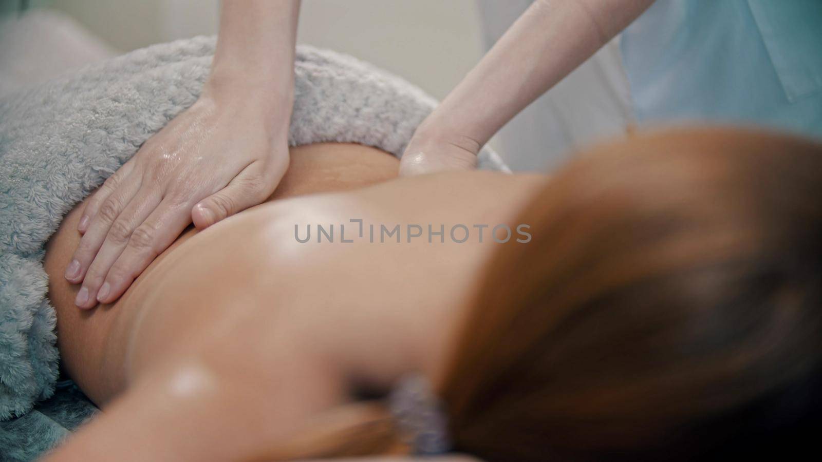 Massage treatment - massage master massaging womans back using oil - indoor