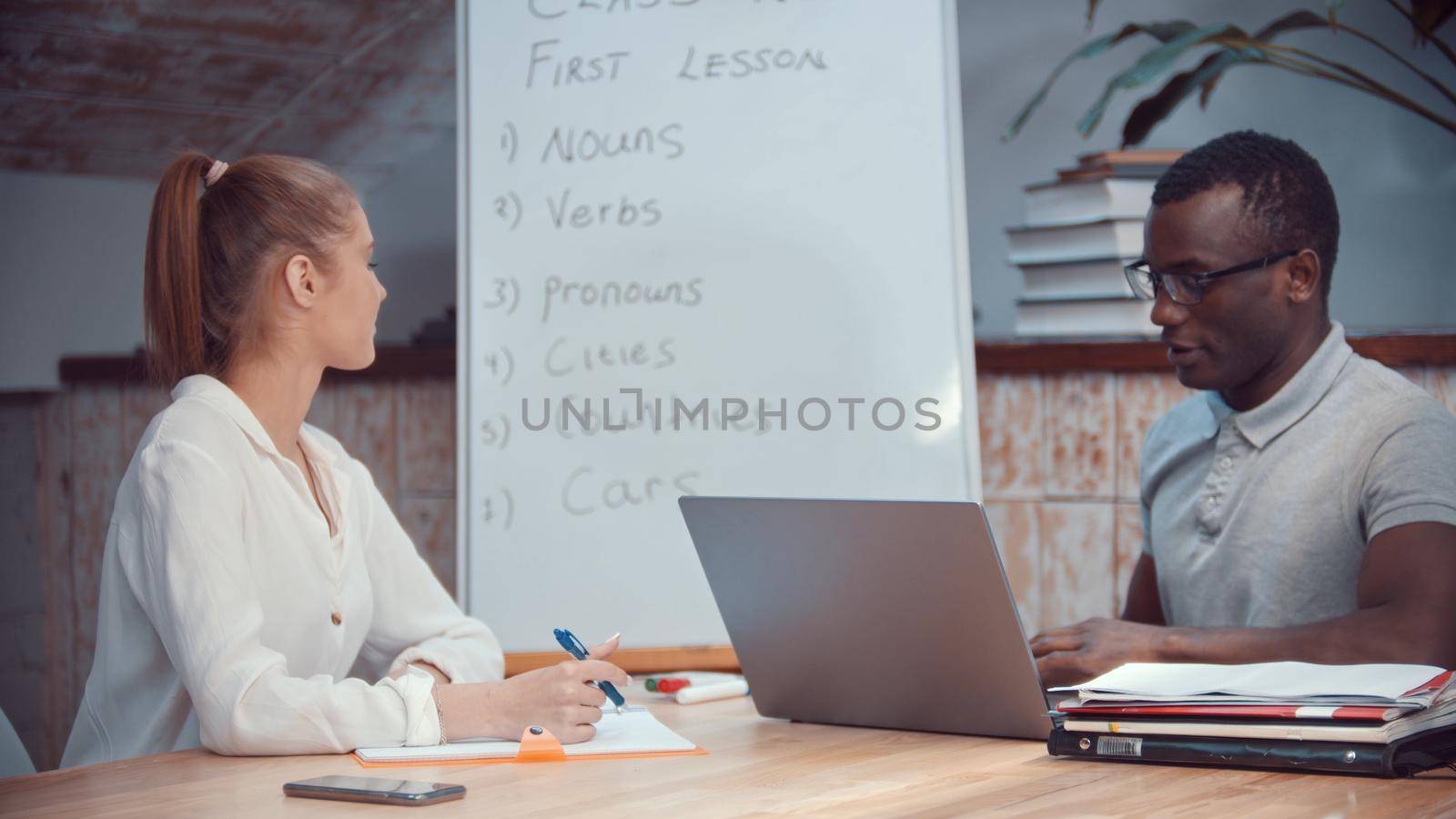 A woman and african-american man having an english class. Mid shot