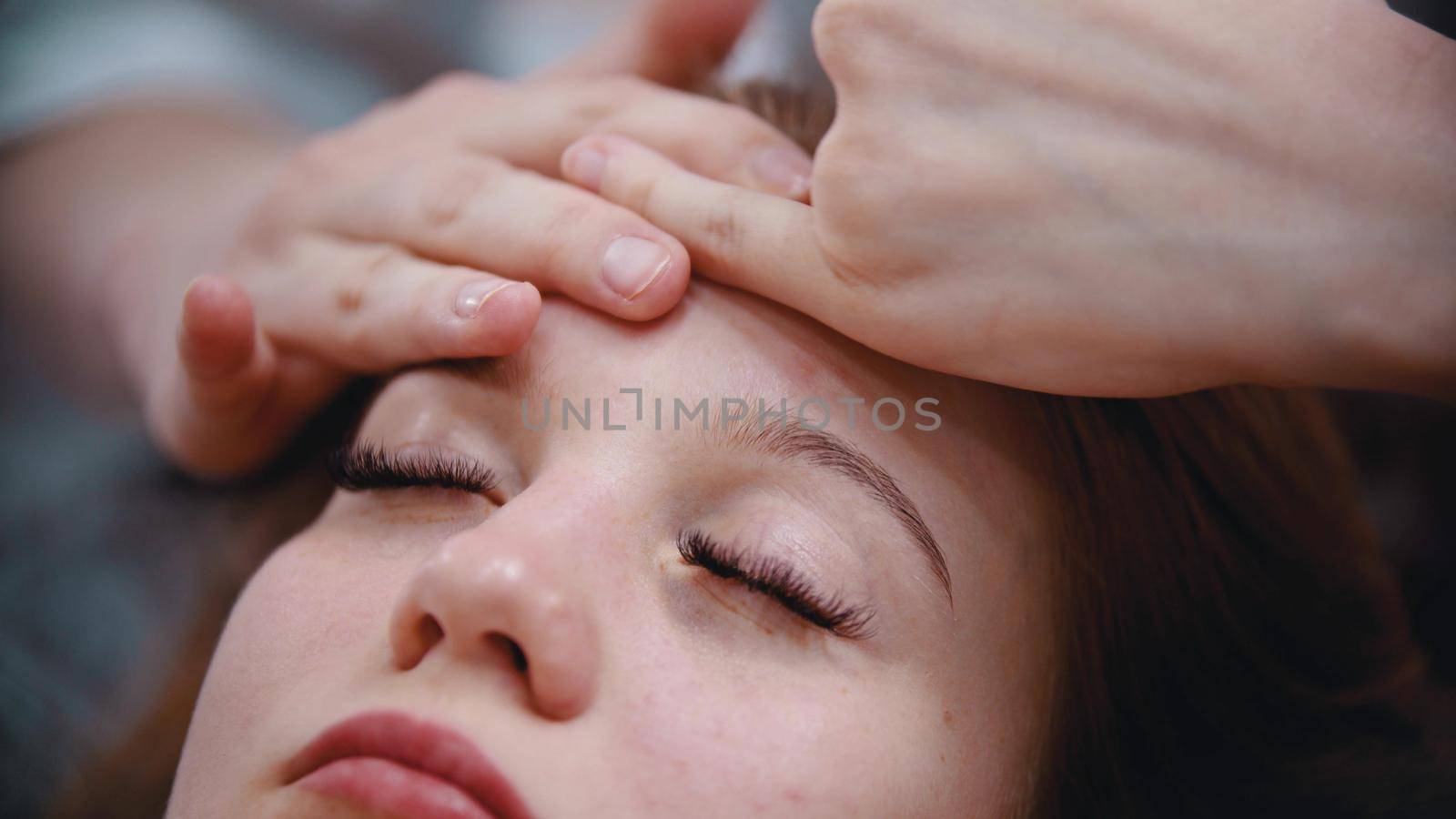 Massage - massage master massaging womans forehead with special technique using fingers - indoor