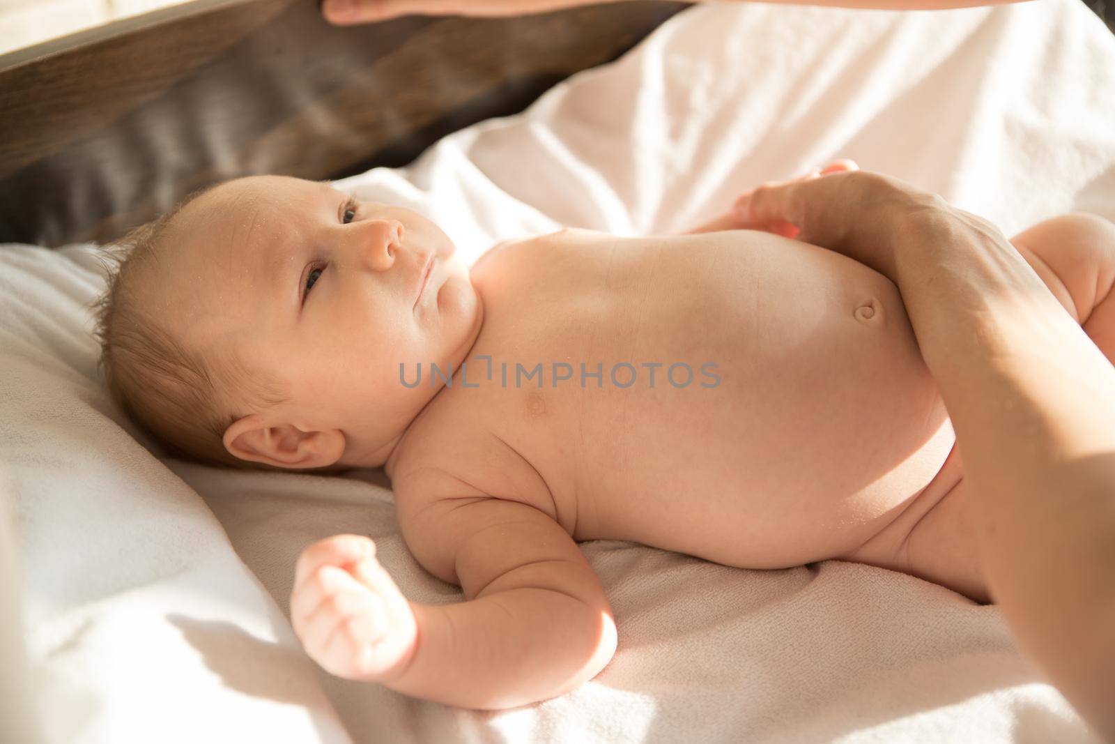 A little baby lying on a bed. Mid shot