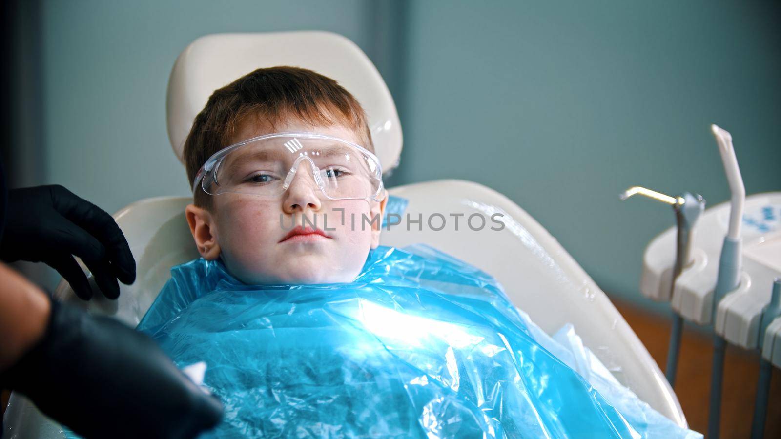 A little boy having his tooth done in the clininc - lying in the couch. Mid shot