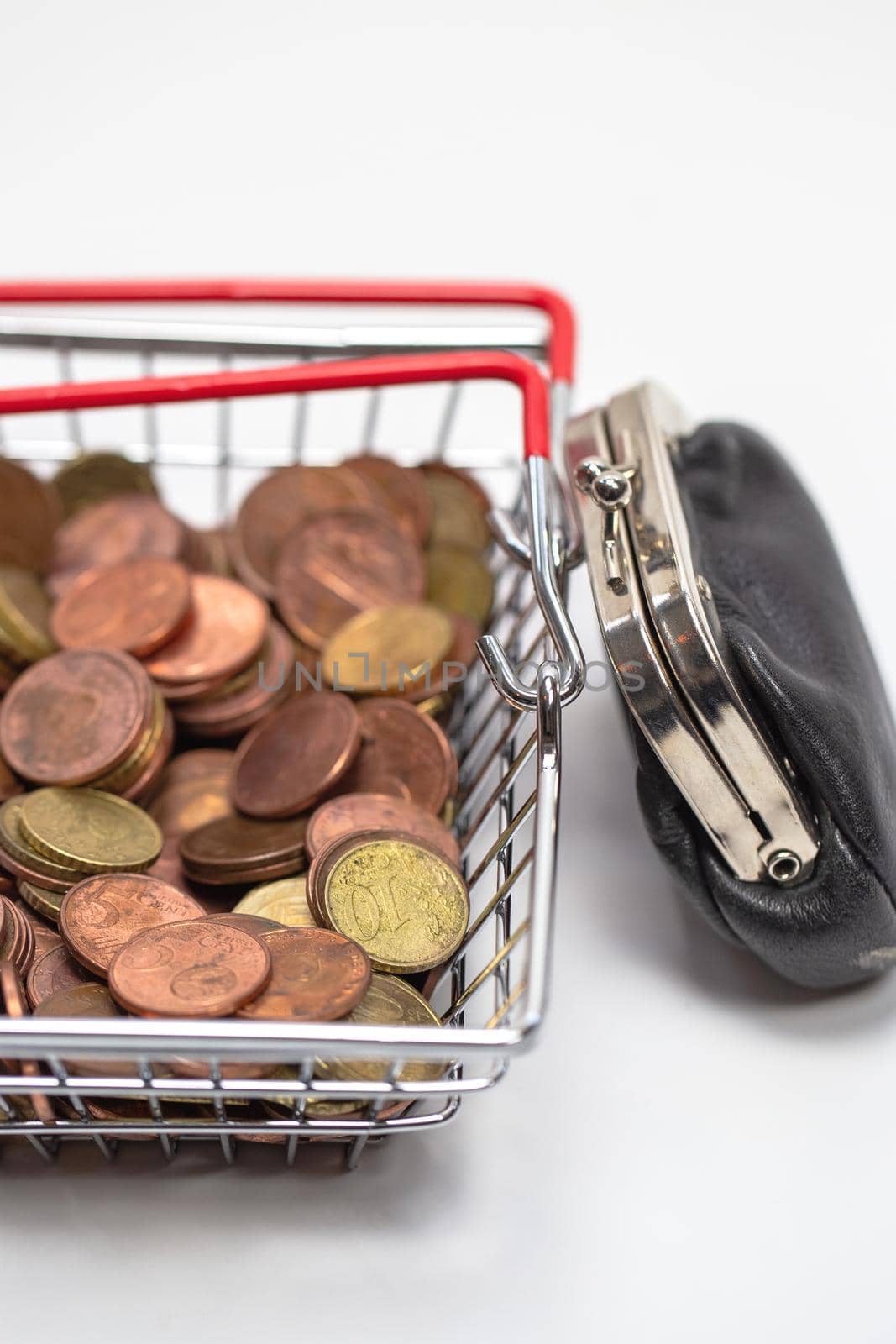 Iron shopping basket filled with euro coins isolated on white background, business and financial concept