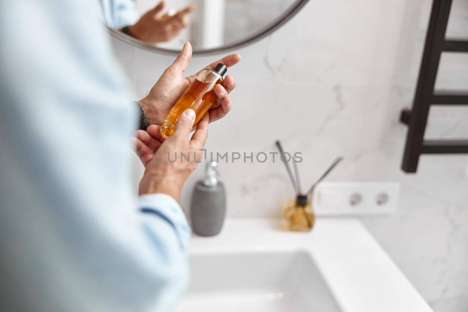 Photo of adult caucasian beautiful man in front of mirror in light modern bathroom by Yaroslav_astakhov