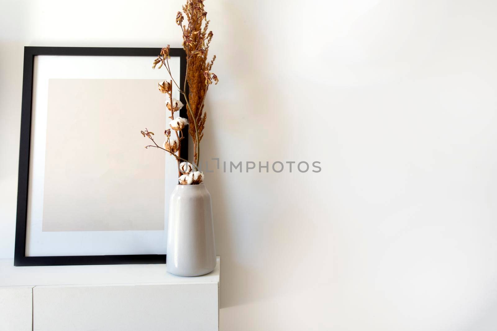 Empty wooden photo,picture frame mock-up with white vase and stylish plant near white wall on table, Copy space modern decoration interior space for text