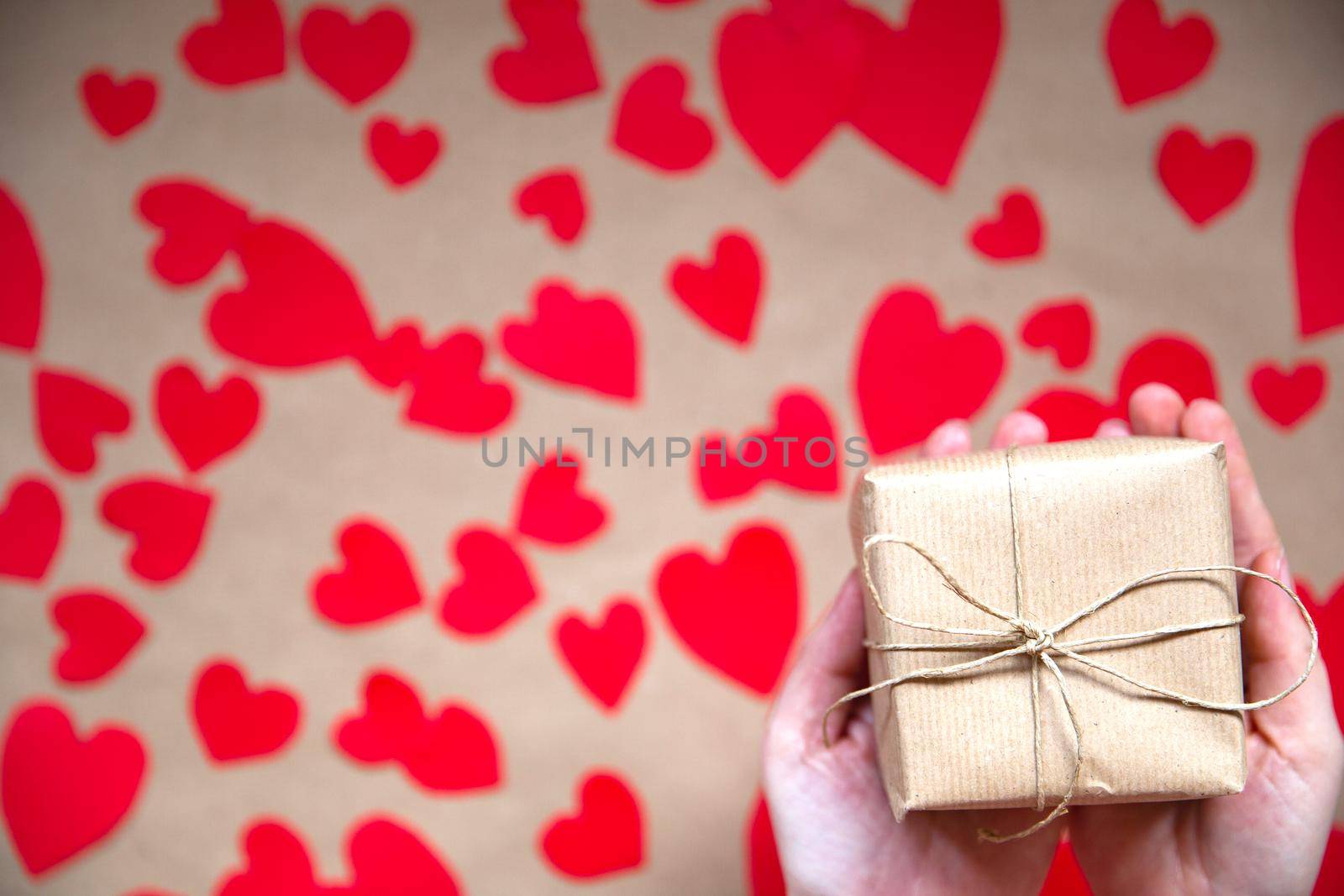 Hands holding beautiful gift box, female giving gift, Valentine's Day, holidays and greeting season concept, top view background romantic design