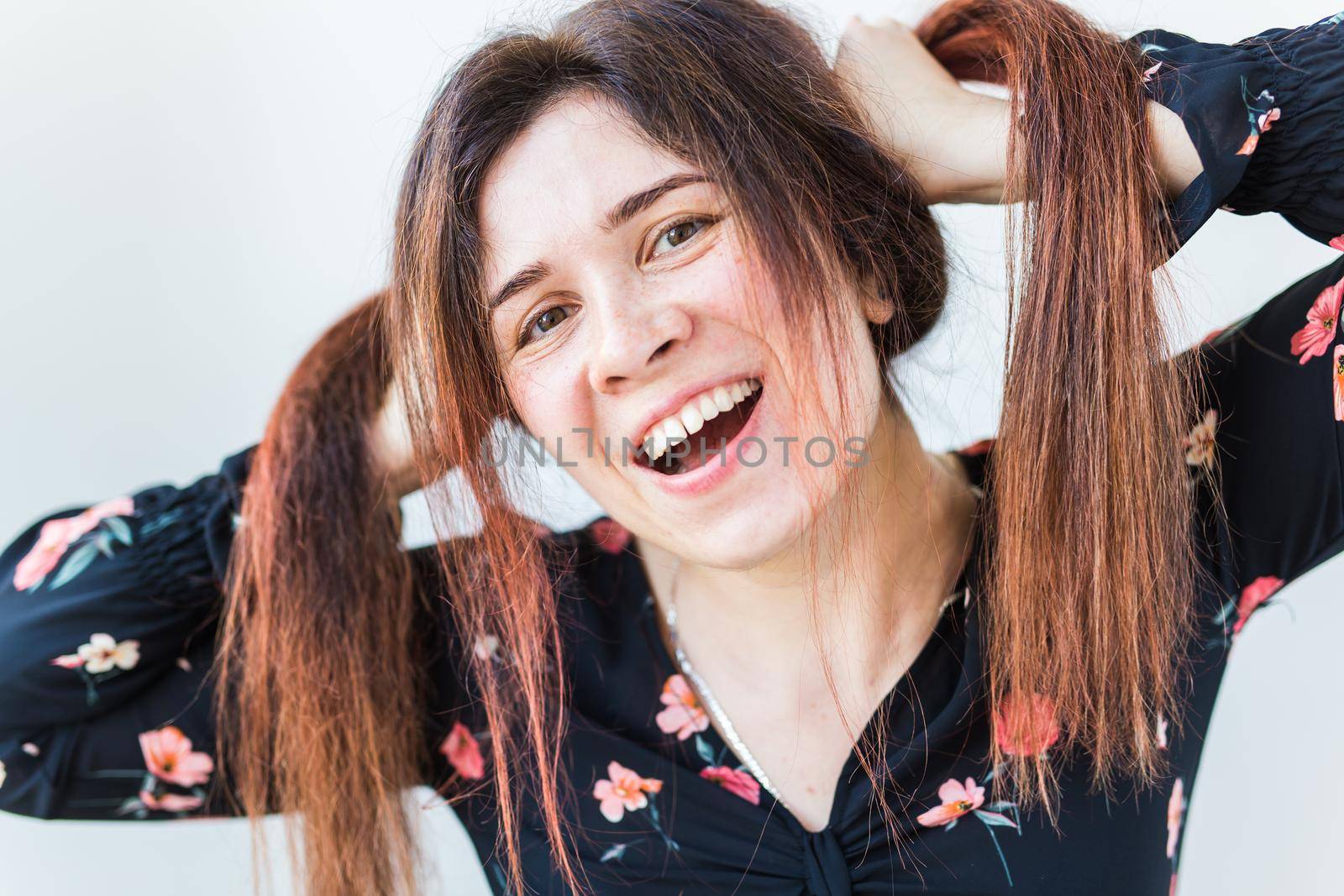 Close up portrait of funny attractive pretty girl with long ginger fair hair standing on white background