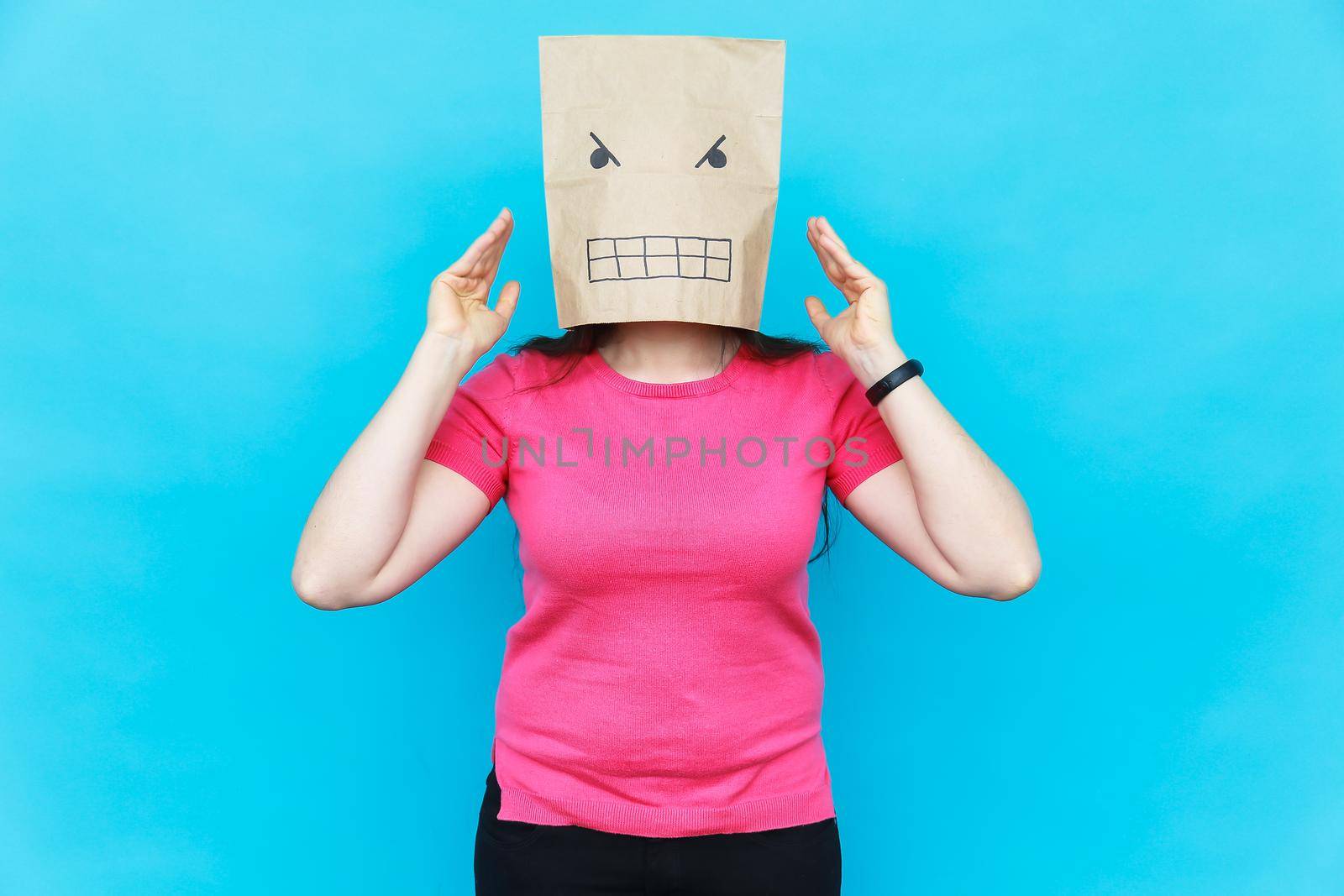 Woman standing with a cardboard on her head with angry face. Emotions concept. by Satura86
