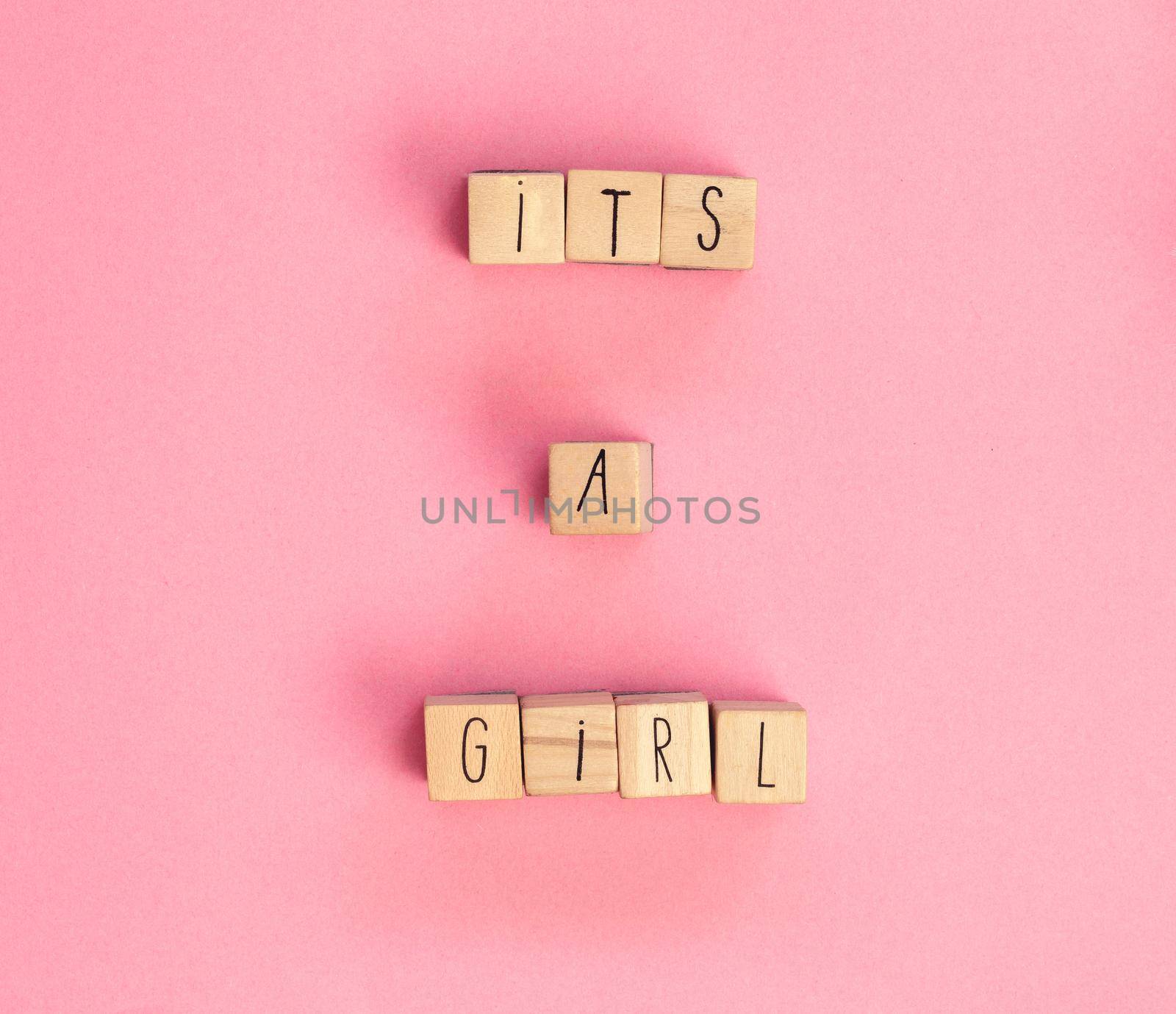 Its a Girl text written with wooden cubes on pastel white background top view, Baby announcement. Flat lay,text space. Greeting card, shower, baby concept bright colorful design cute