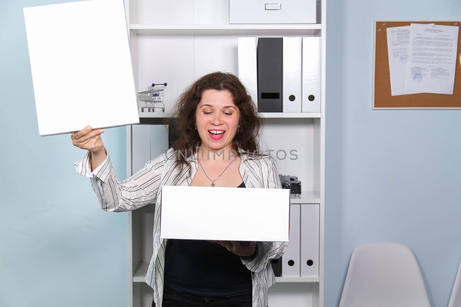 Concept of dismissal from work. Happy woman with carton box with her stationery stuff, girl was fired from her job
