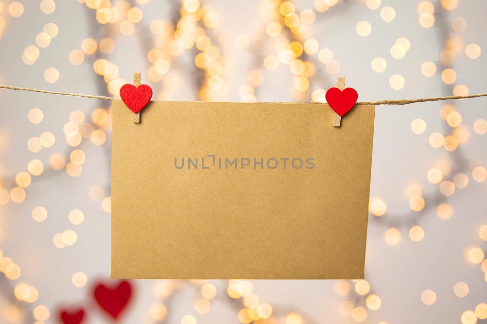 Blank letter, envelope or greeting card hanging with red hearts, romantic love letter , Valentines Day concept bokeh background, copy space romantic design