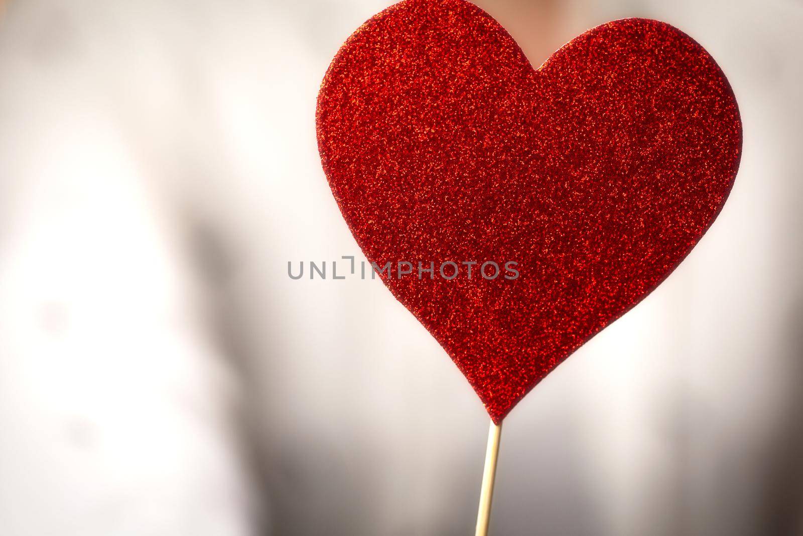 Female hands holding sparkling red heart near body, taking care, Health, Valentine's Day concept romantic design love background