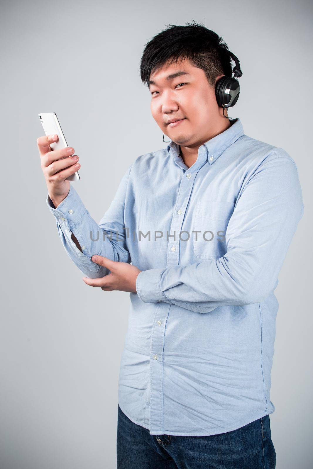 man in headphones holding mobile phone and smiling by whatwolf