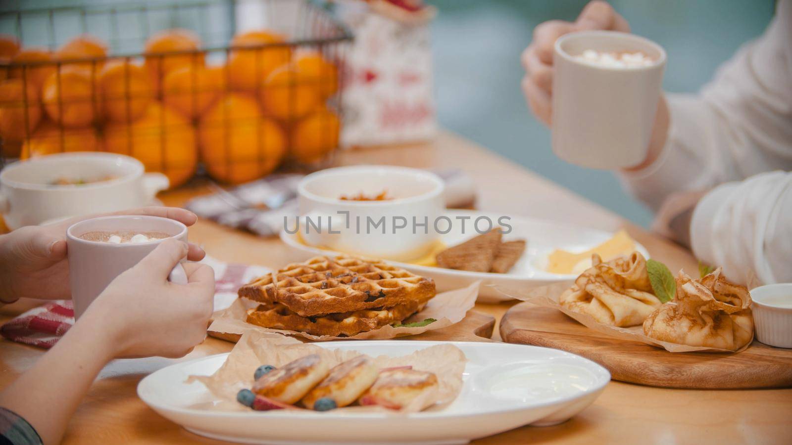 A couple in restaurant having a breakfast of waffles and pancakes. Mid shot