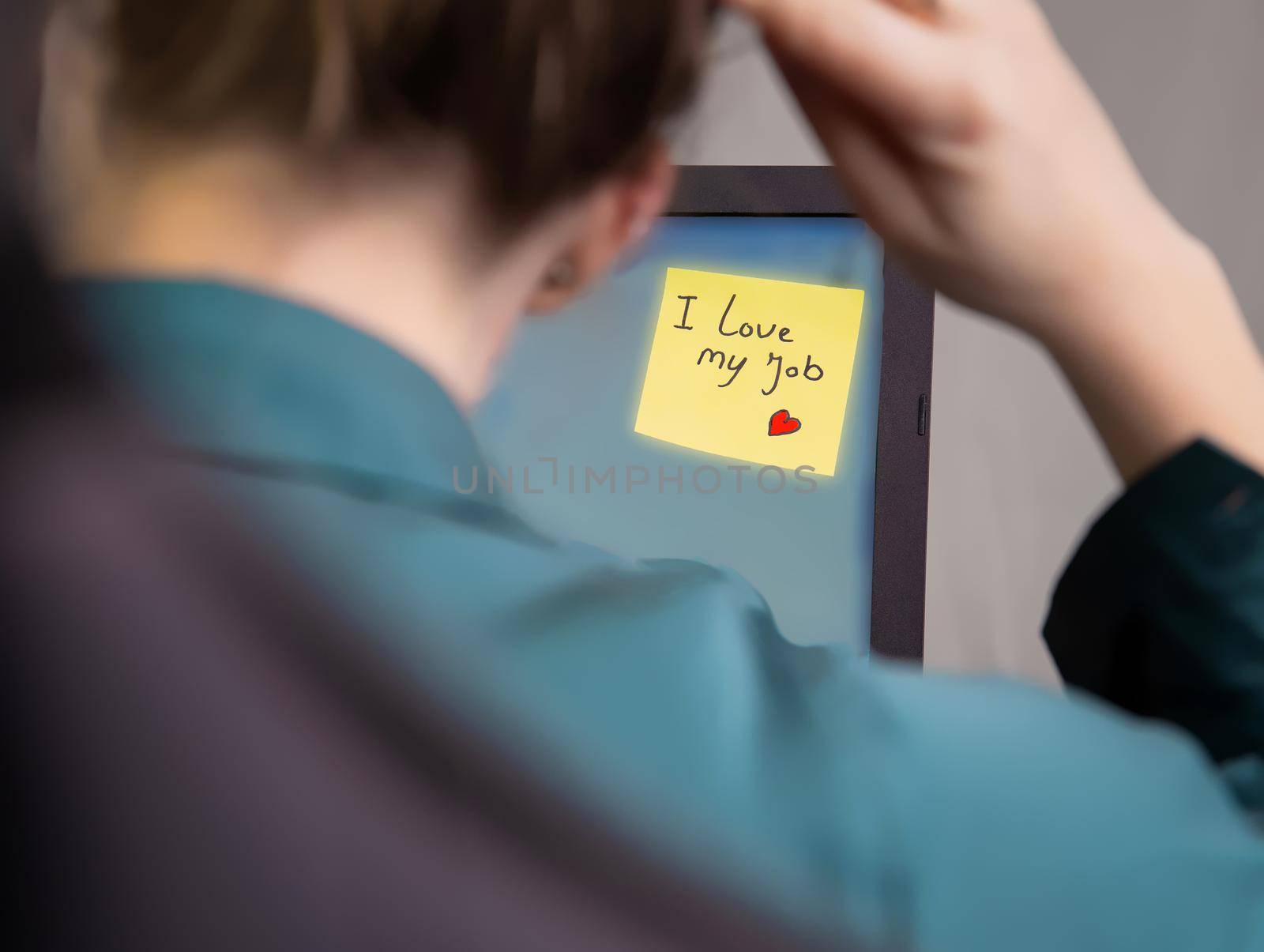 Business woman sitting in her home office with laptop and sticky note with the text I Love my job, business,work, passion,ambition,motivation concept copy space modern background