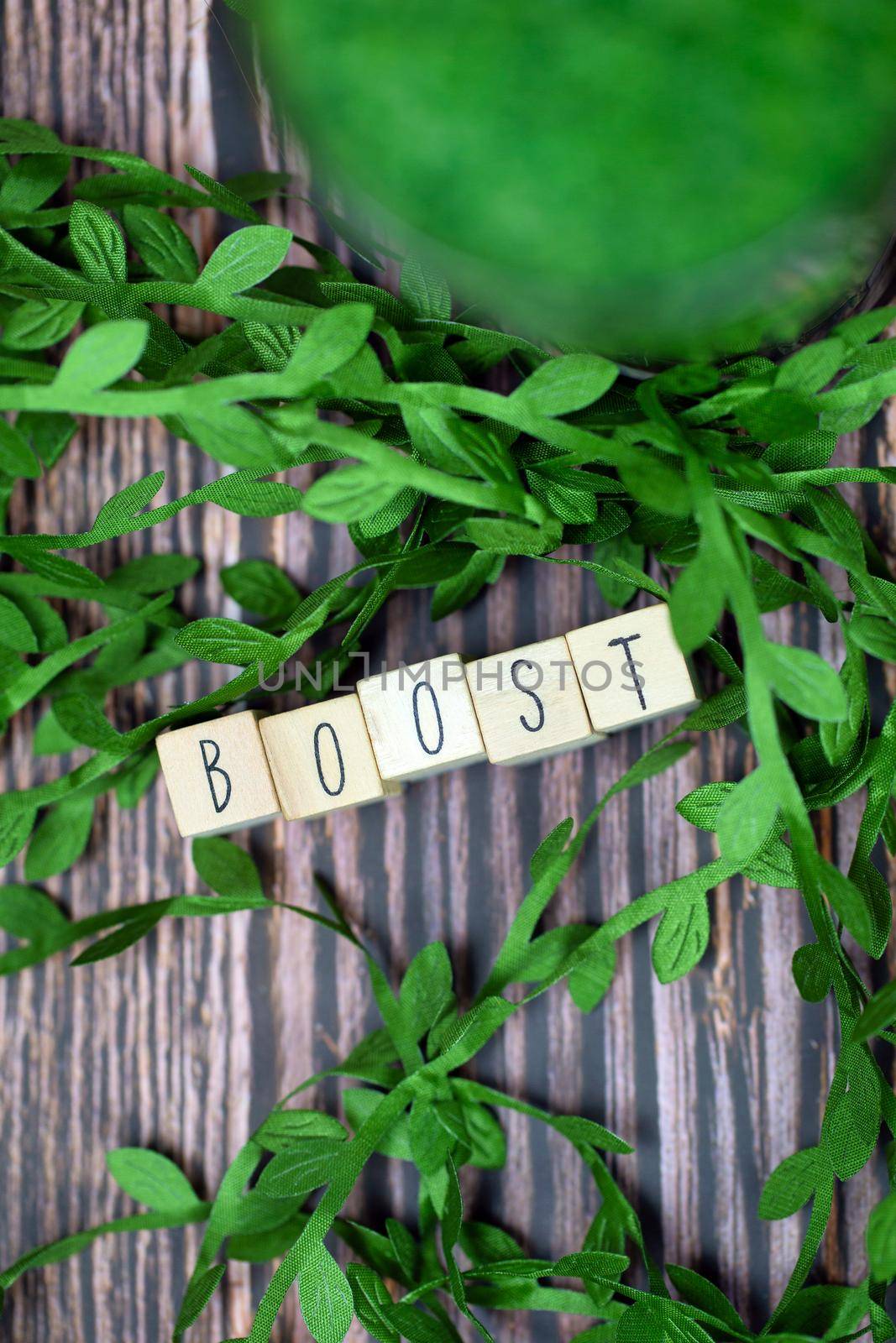 Boost text wooden cubes immune system text with wooden cubes and fresh organic leafs on background with wood texture, Boost for Healht concept by Annebel146