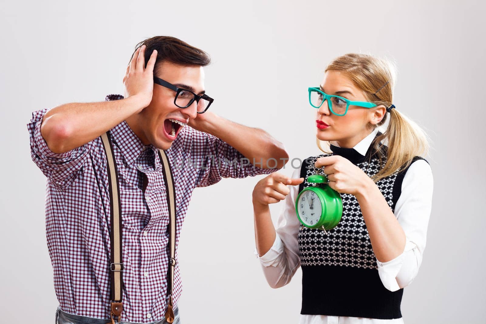 Portrait of nerdy woman showing clock to her nerdy boyfriend.