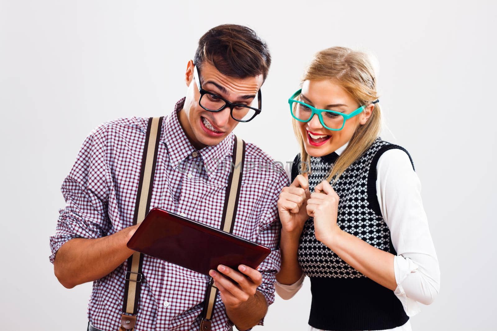 Nerdy man and nerdy woman are using digital tablet.