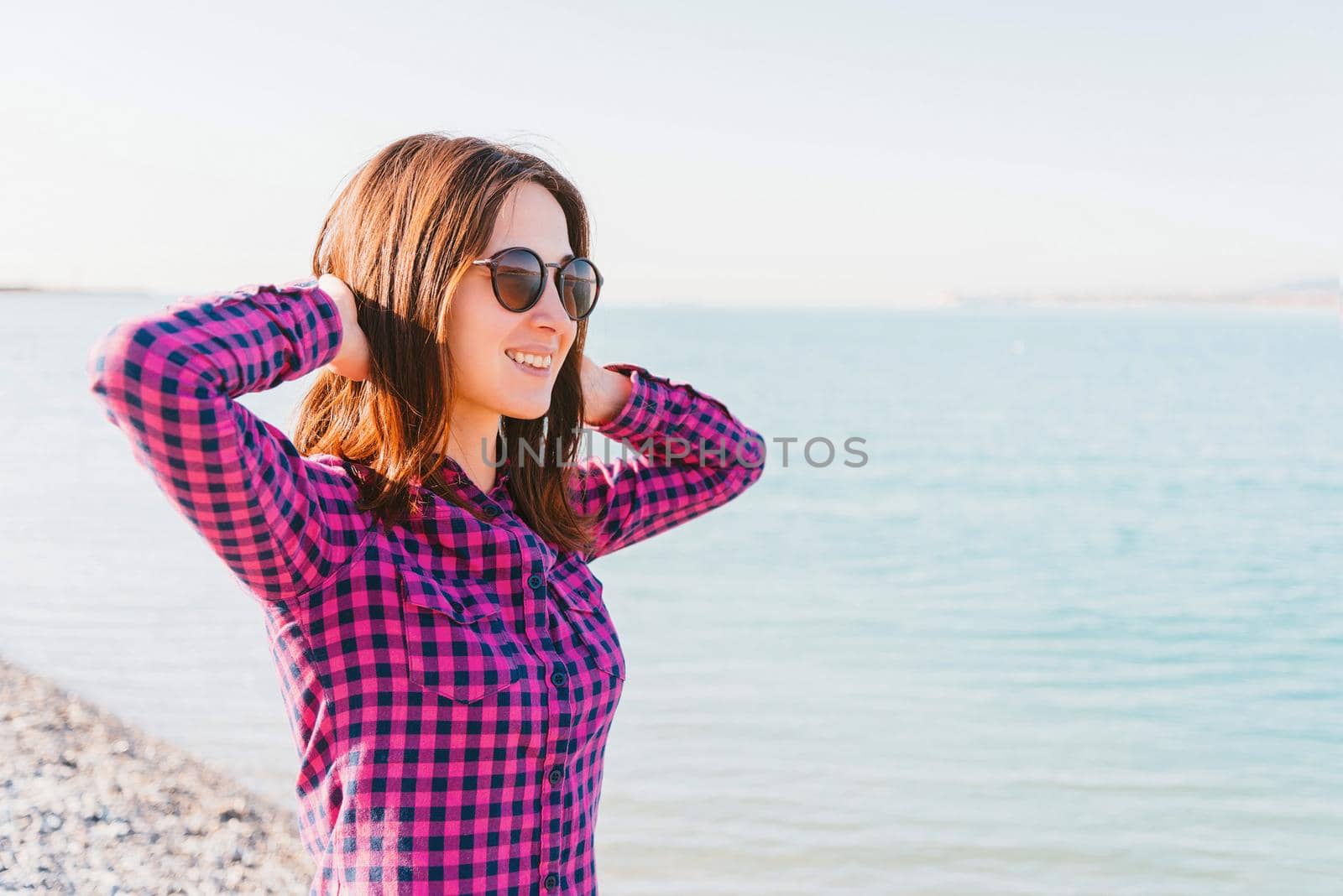 Happy woman in sunglasses enjoying a nice day near the sea