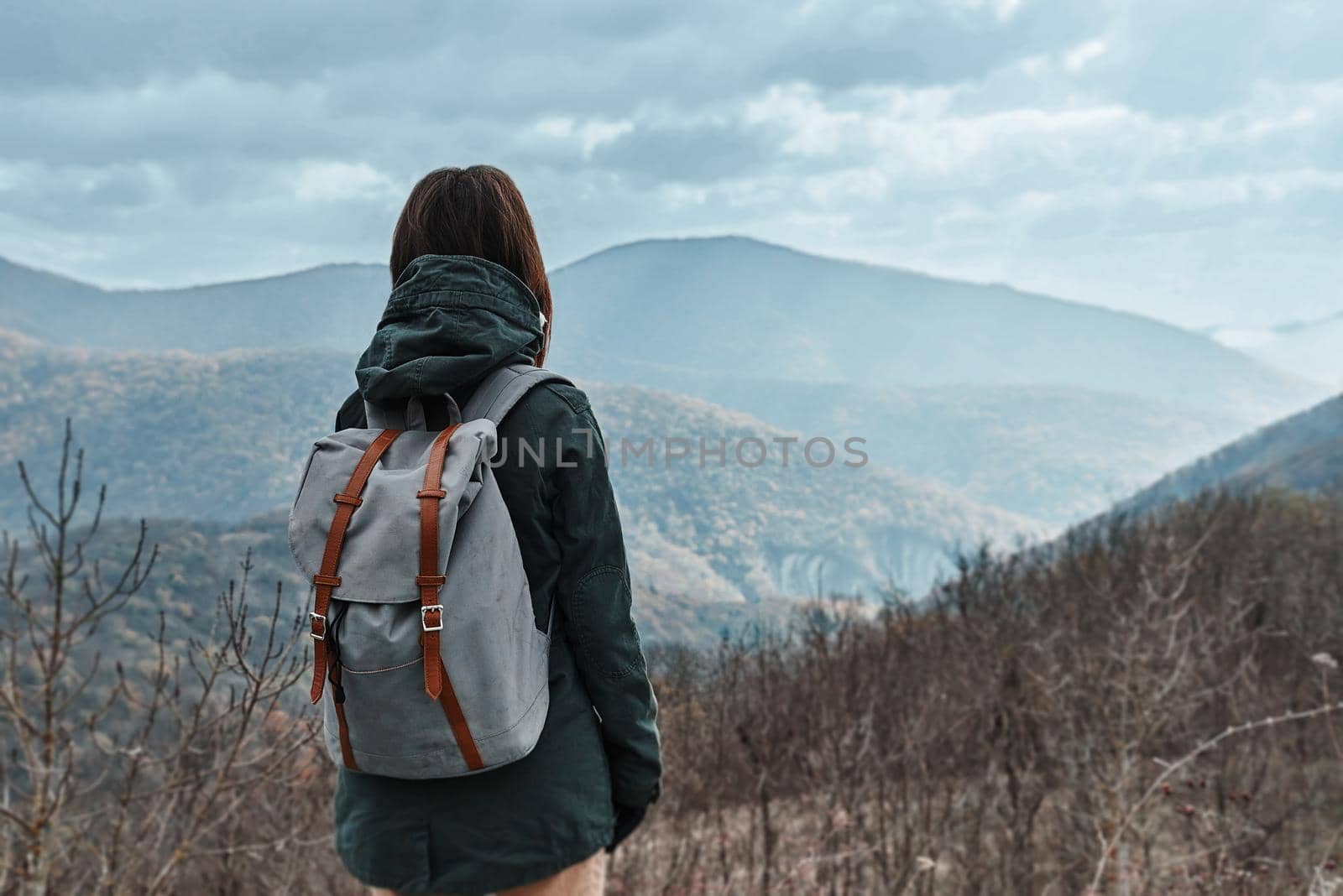Hiker woman with backpack in mountains at autumn season