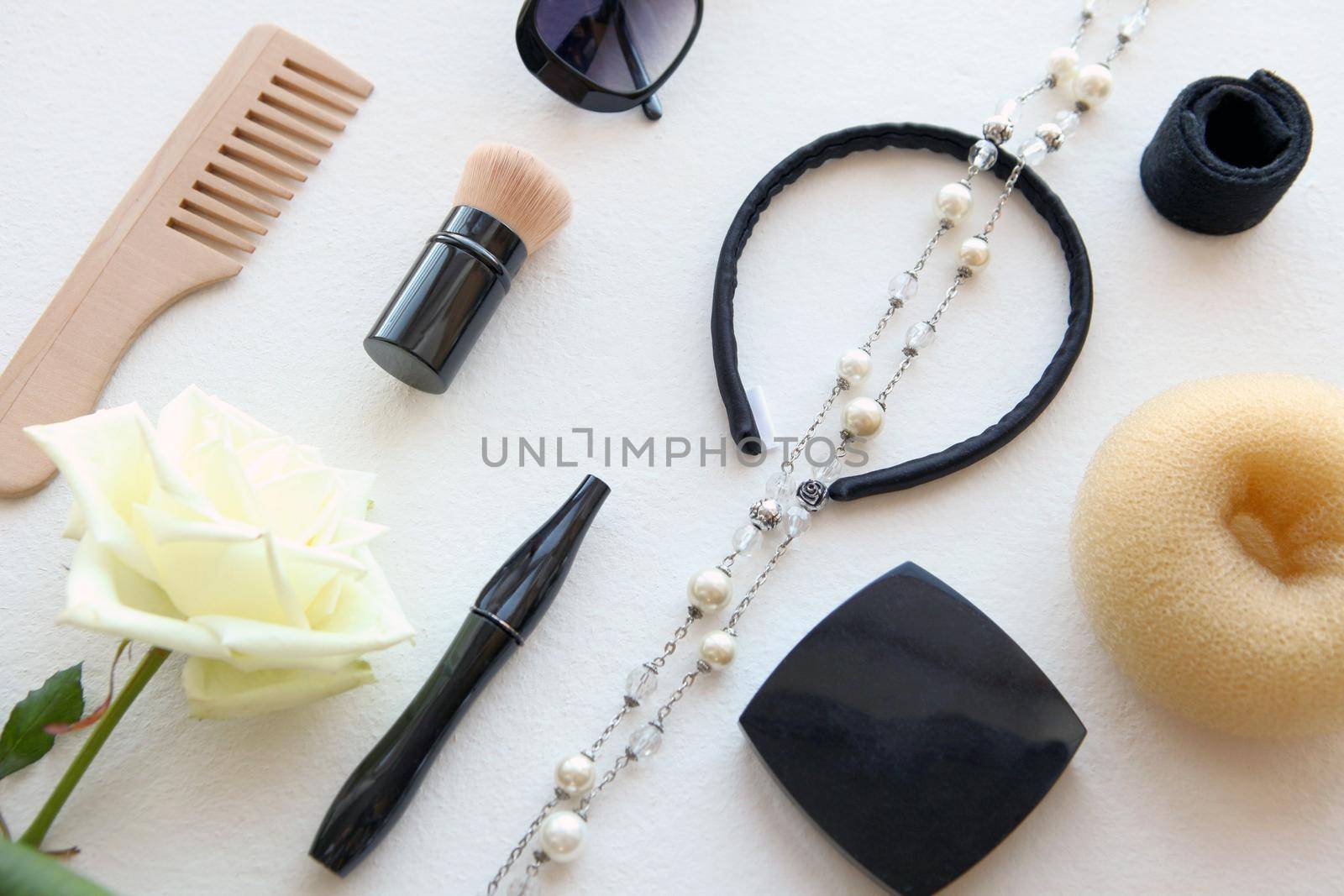 wooden Hairbrush, sunglasses, barrette and Scrunchy isolated on white. Flat lay black Hairdressing tools and other woman beauty accessories with white rose and pearls.