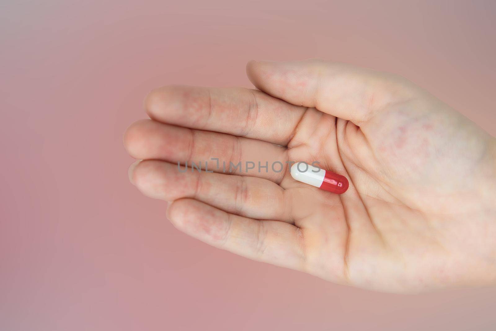 hands holding red and white capsules for medication, vitamin or drugs background on white background. Top view. Flat lay. Copy space. Close up. Medicine,business and health concept colorful