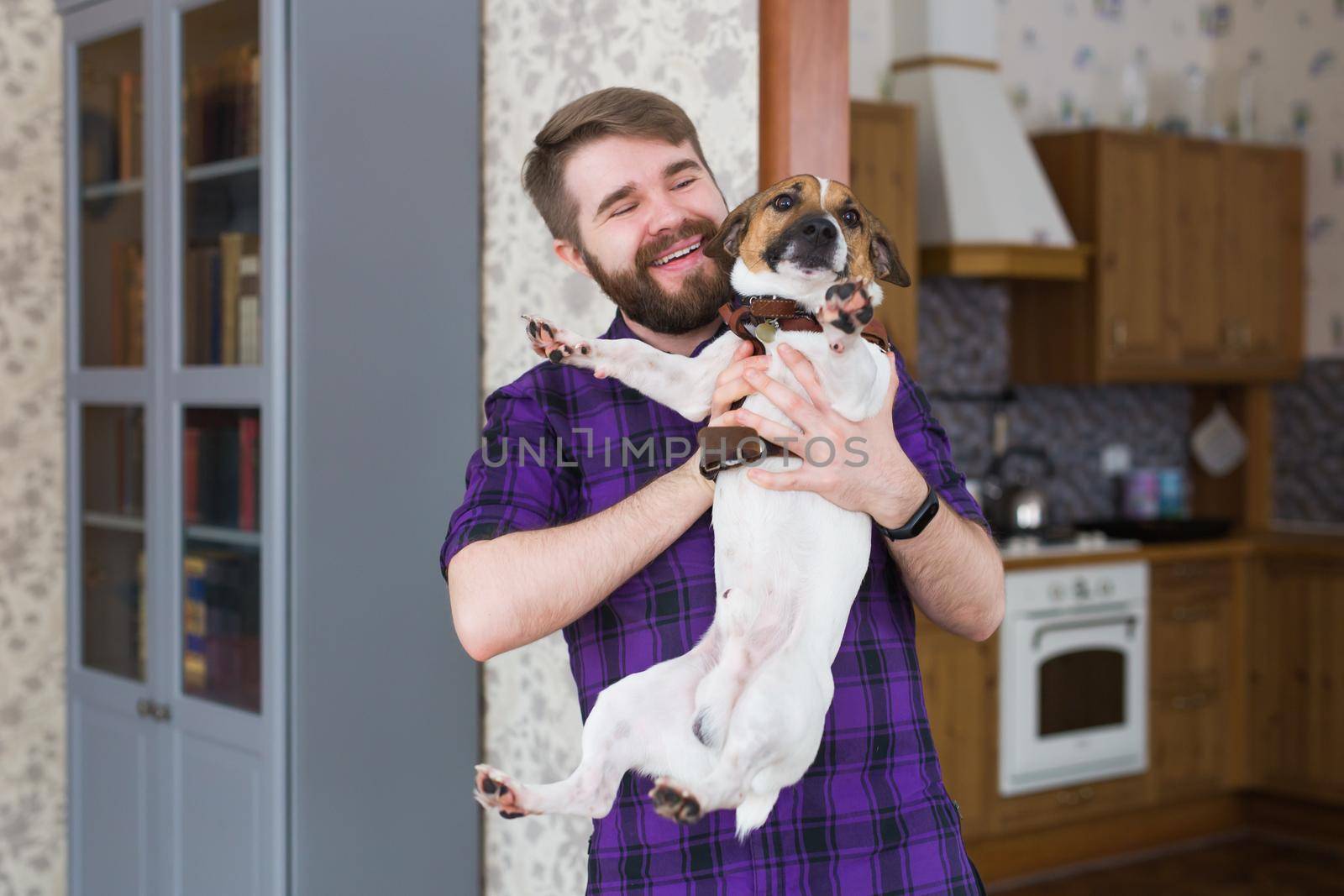 Close Up portrait handsome young hipster man loves his good friend dog at home. Positive human emotions, facial expression, feelings.