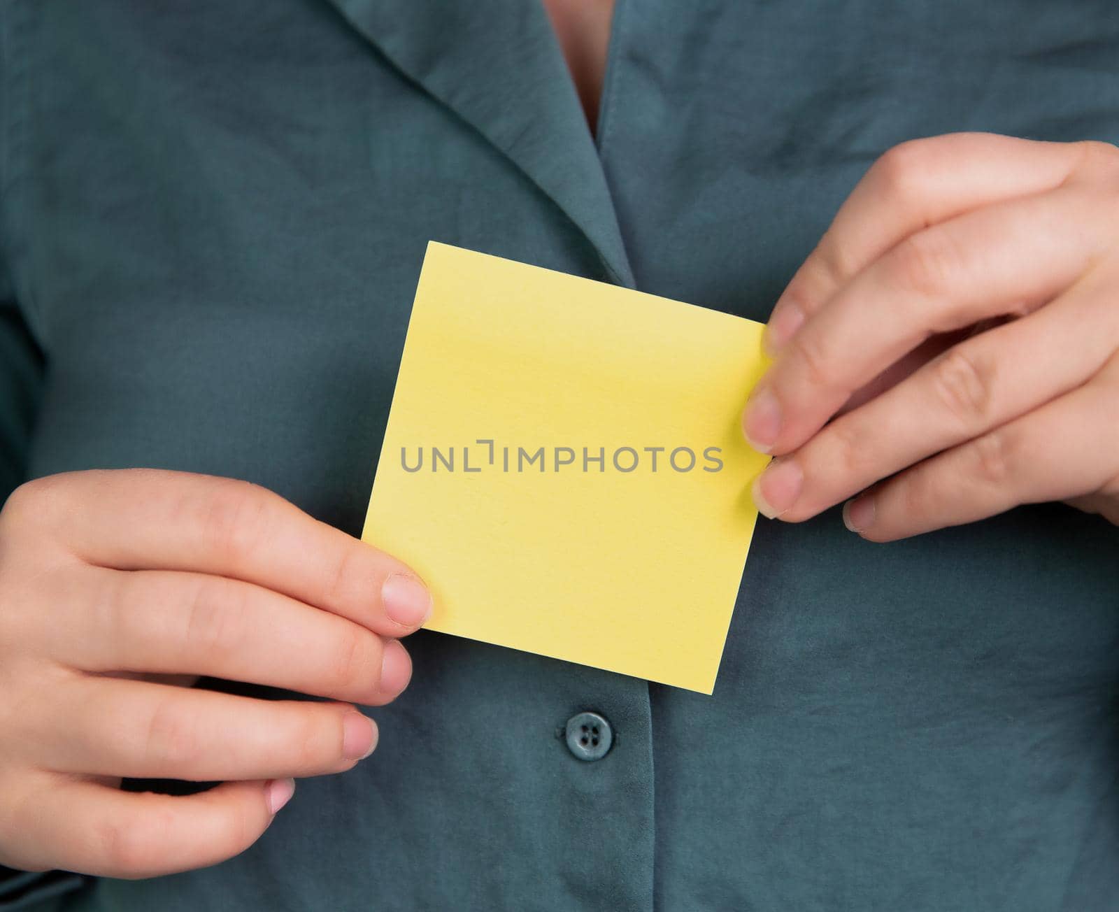 Business woman holding a blank yellow memo notepaper, sticky note for copy space, space for text, business,communication,education,design concept close-up