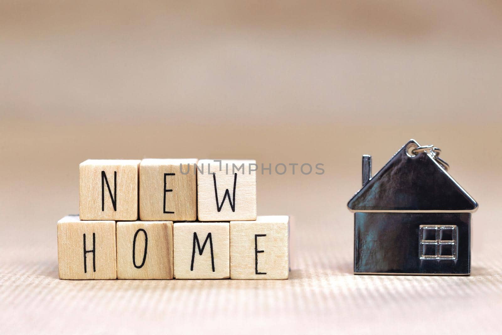 New Home text written with wooden cubes background with symbol of cozy little house with blurred background design, purchase real estate,mortgage loan, property owner concept background close up
