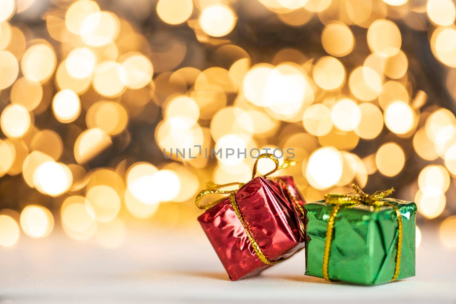christmas present red and silver baubles against bokeh lights gold shiny glitter background with copy space, space for text