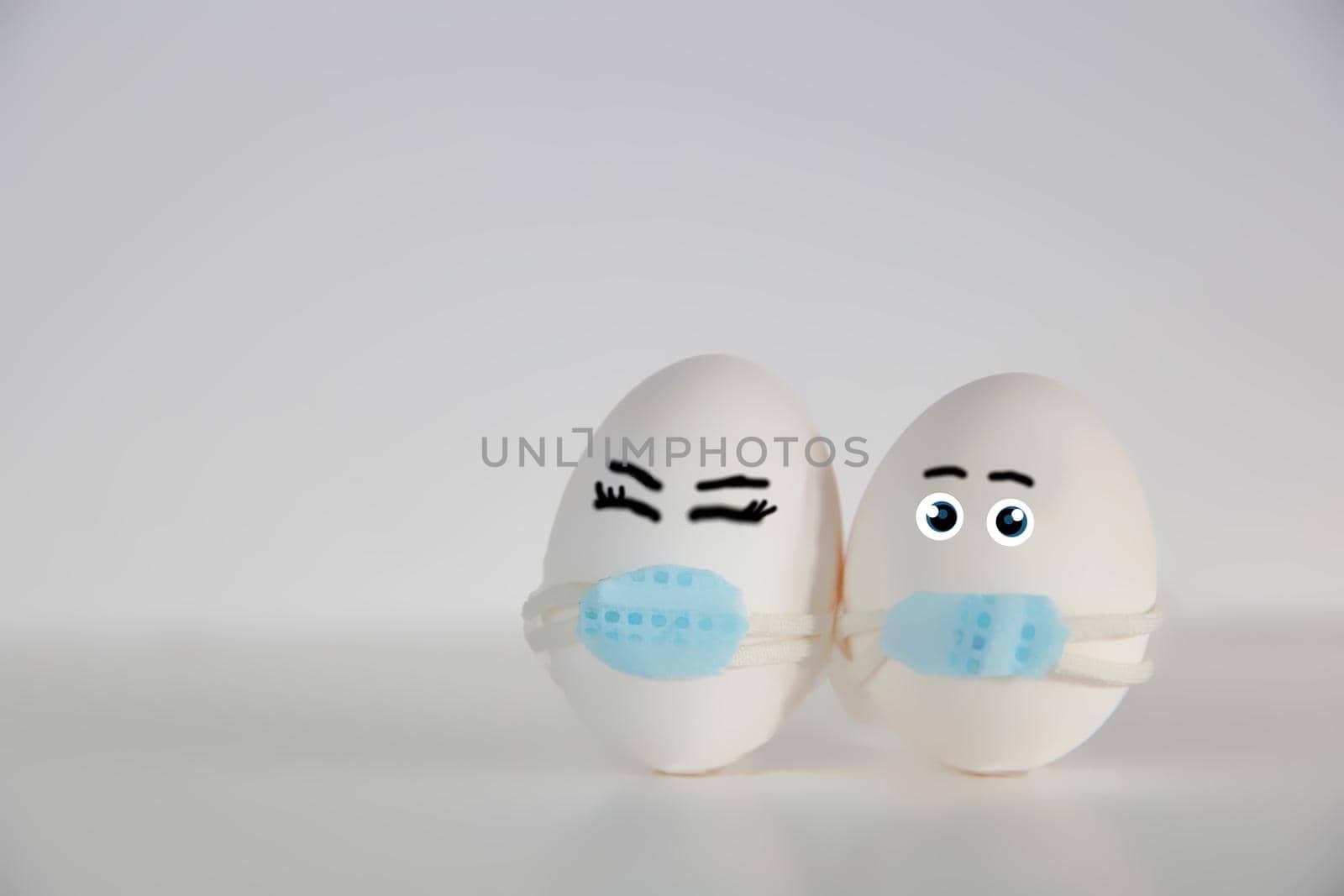 Easter eggs with Corona virus COVID19 protection concepts. DIY Do It Yourself easter eggs wearing mask for Easter holidays decoration on white background Selective focus with copy space. COVID-19 protection coronavirus