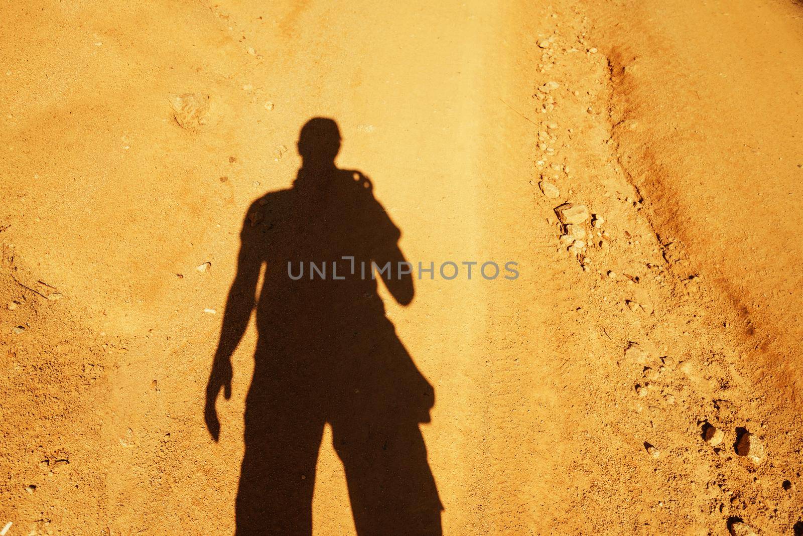 Man takes photographs his shadow on ground