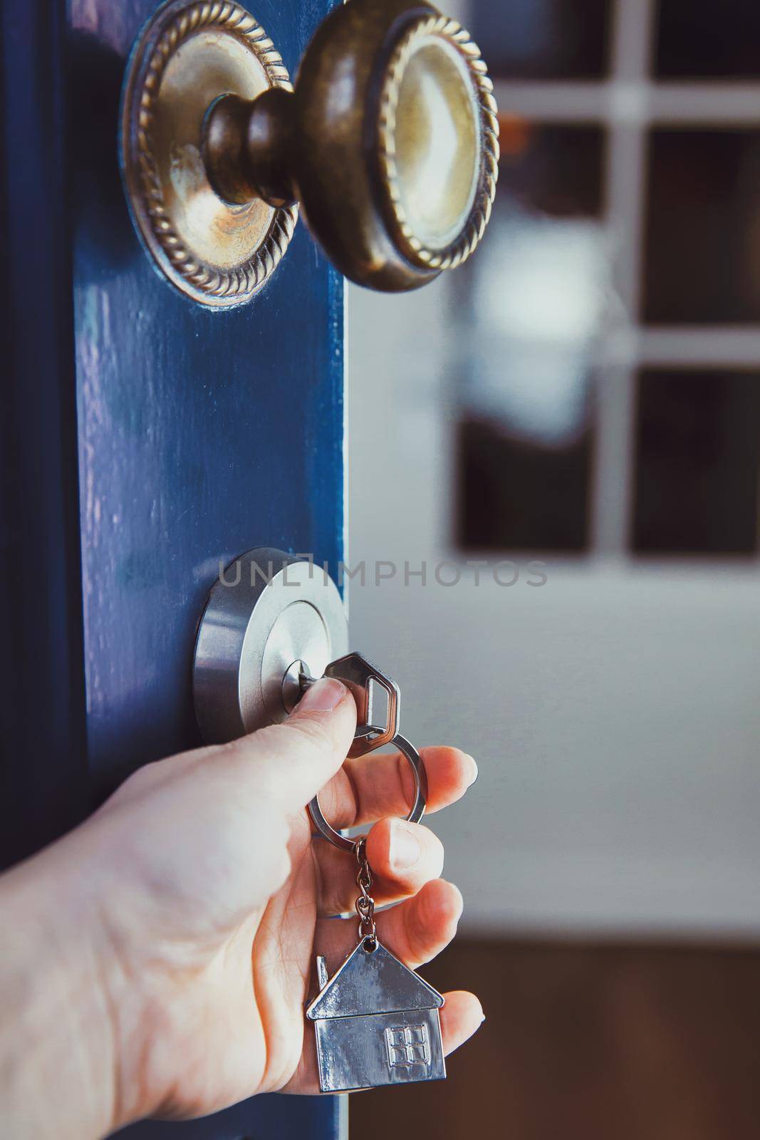 landlord, Estate agent or new home owner opening the door of a cozy new home with silver key, invesment real estate, business, financial concept copy space close up