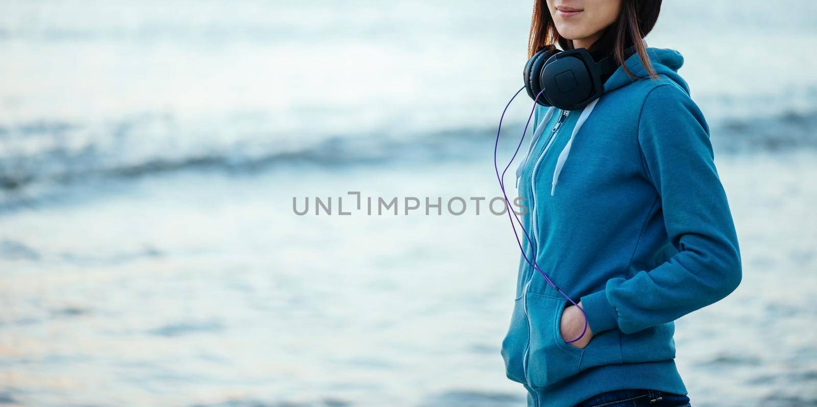 Girl with headphones on background of sea by alexAleksei