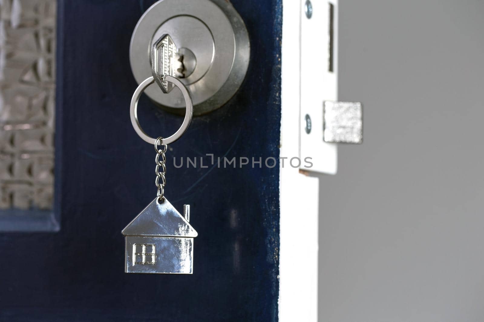 Open door to a new home with key and home shaped keychain. Mortgage, investment, real estate, property and new home concept business
