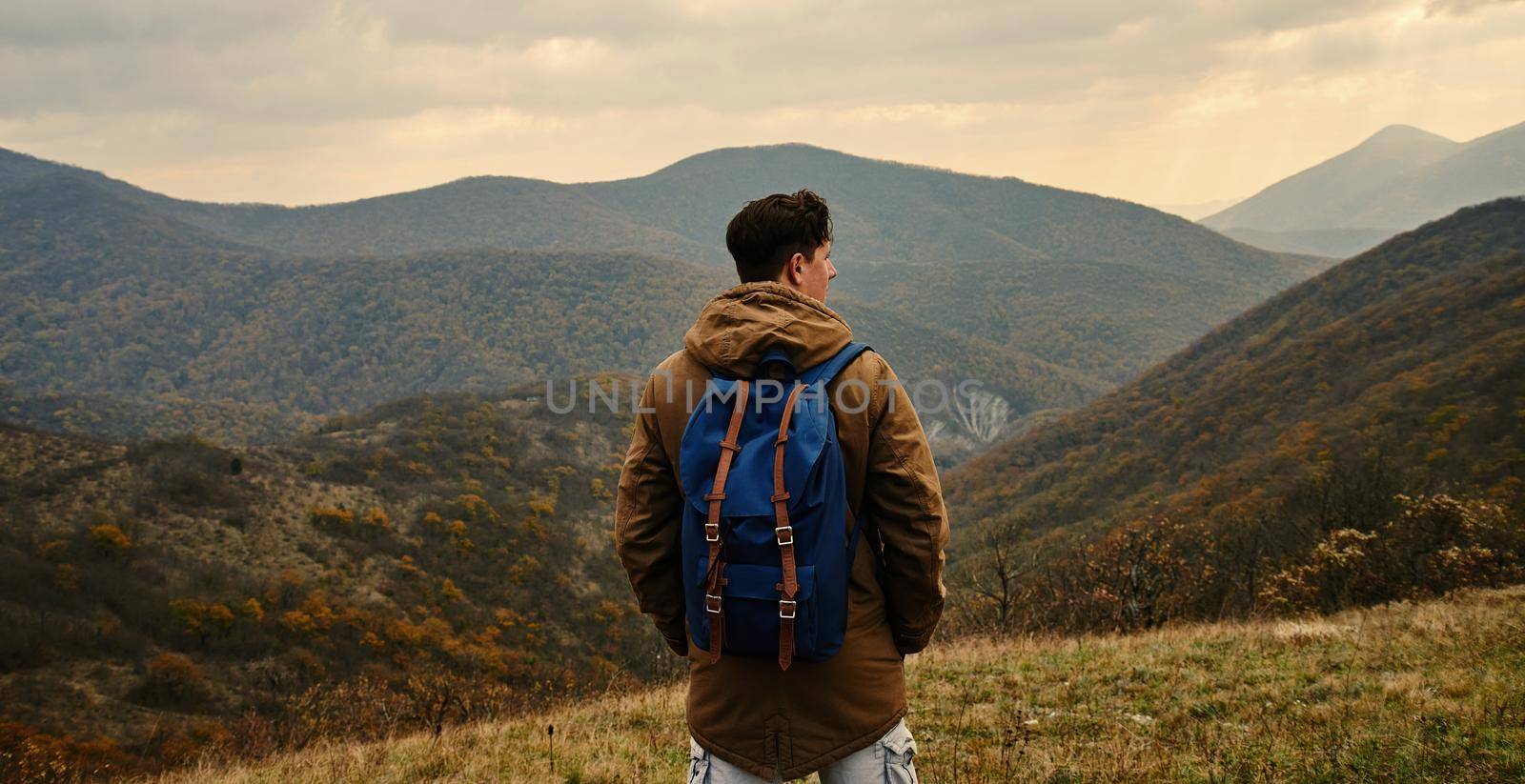 Hiker man with backpack in mountains at autumn season