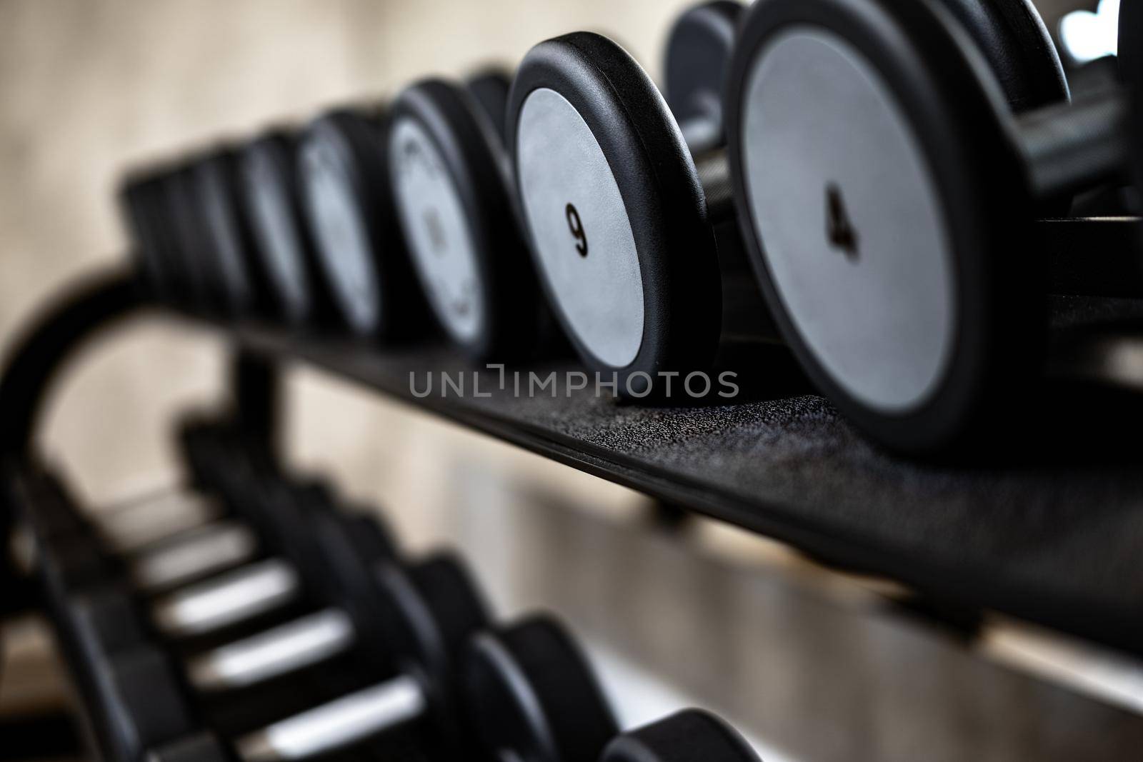Close up photo of new dumbbells on a rack in a gym