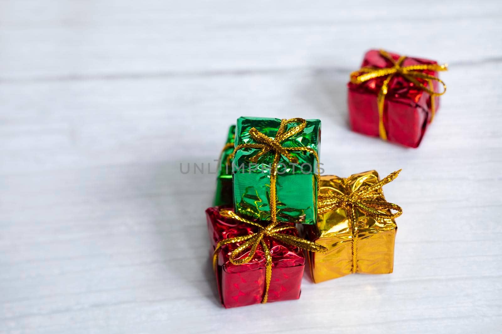 Pile of colored shiny gift boxes with copy space on white wood background,modern retro Christmas design, Colorful presents,Holiday concept space for text
