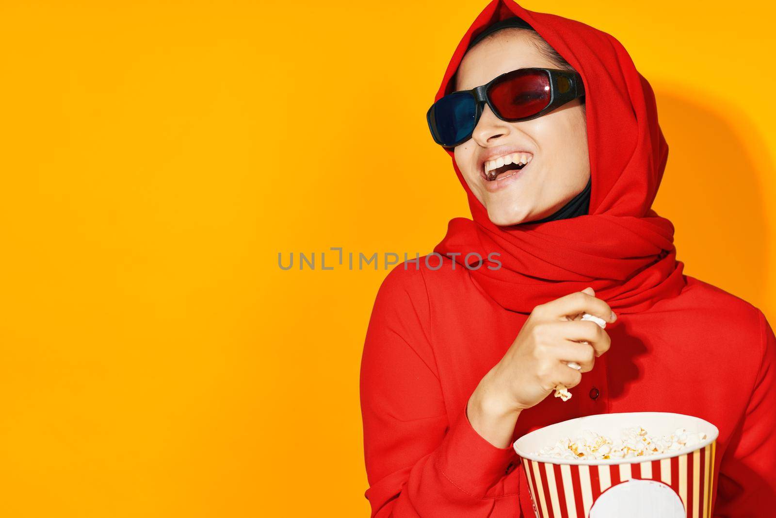 arab woman 3d glasses technology watching movie popcorn yellow background. High quality photo