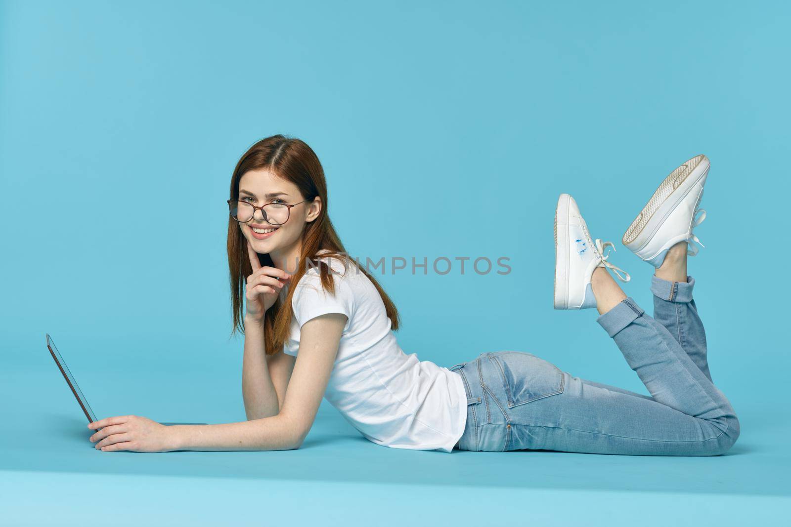 woman with laptop learning internet online education blue background. High quality photo